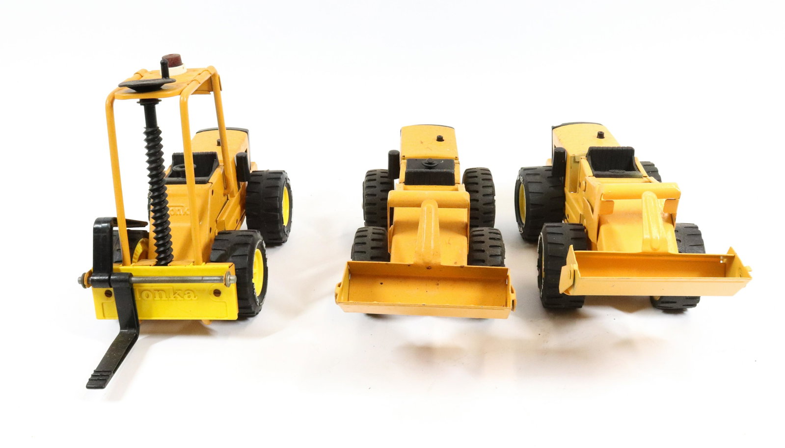 (3) TONKA TOYS LOADERS AND FORKLIFT: PRESSED METAL WITH PLASTIC TIRES. 8" TO 10" L.