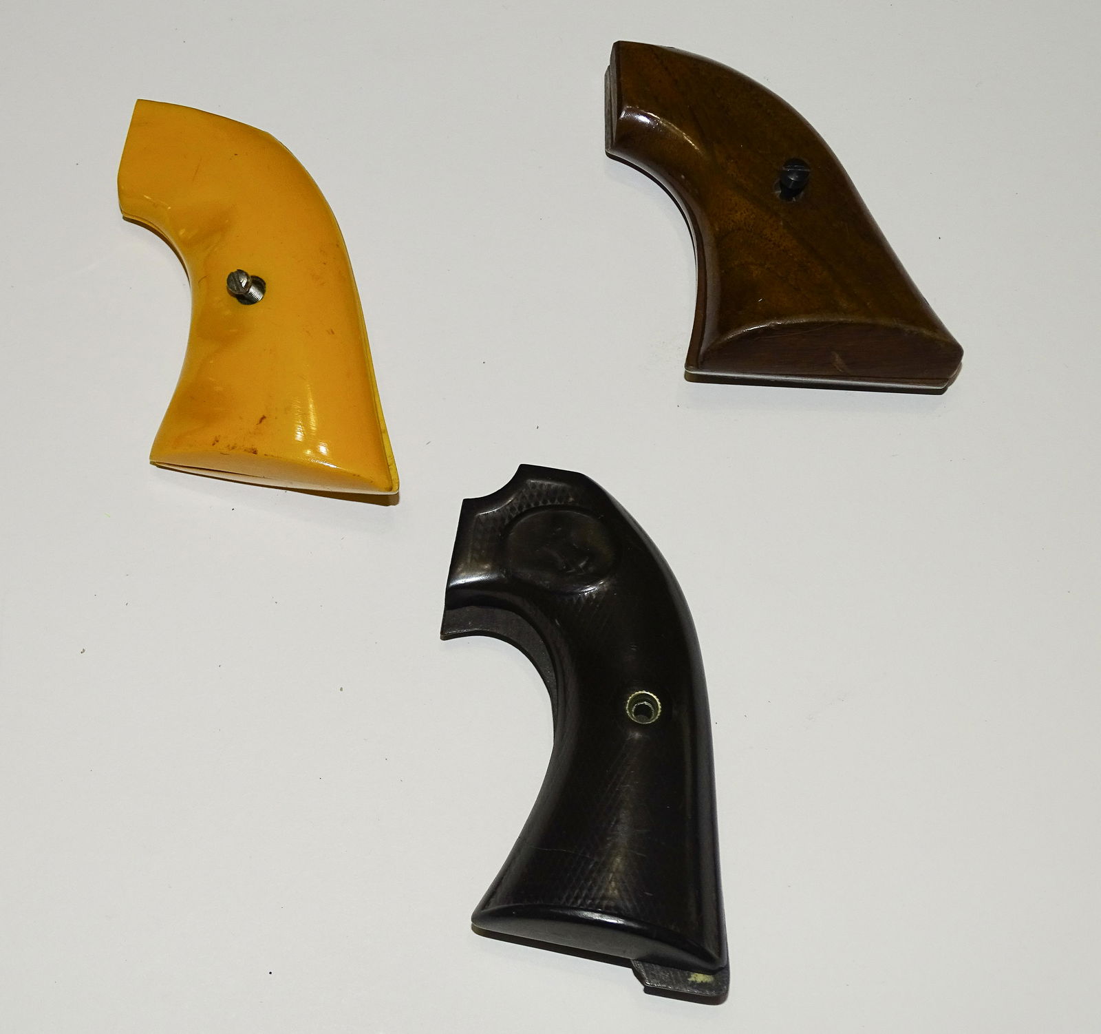 (3) PAIR REVOLVER GRIPS: WALNUT, YELLOW BAKELITE AND WORN COLT BAKELITE 3 1/2" UPDATED 2023 Terms for Purchasing and Shipping of Auction Items. Please read carefully before bidding. All payments for purchases will be made thr