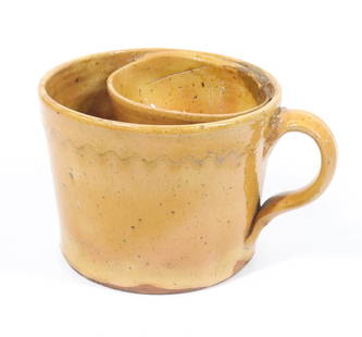 REDWARE SHAVING MUG: ORANGE/YELLOW GLAZE WITH INCISED WAVY LINE. APPLIED HANDLE AND INTERIOR CUP. 3 3/4" X 5". PLEASE READ CAREFULLY - Terms for Purchasing and Shipping of Auction Items. Please read carefully before biddi
