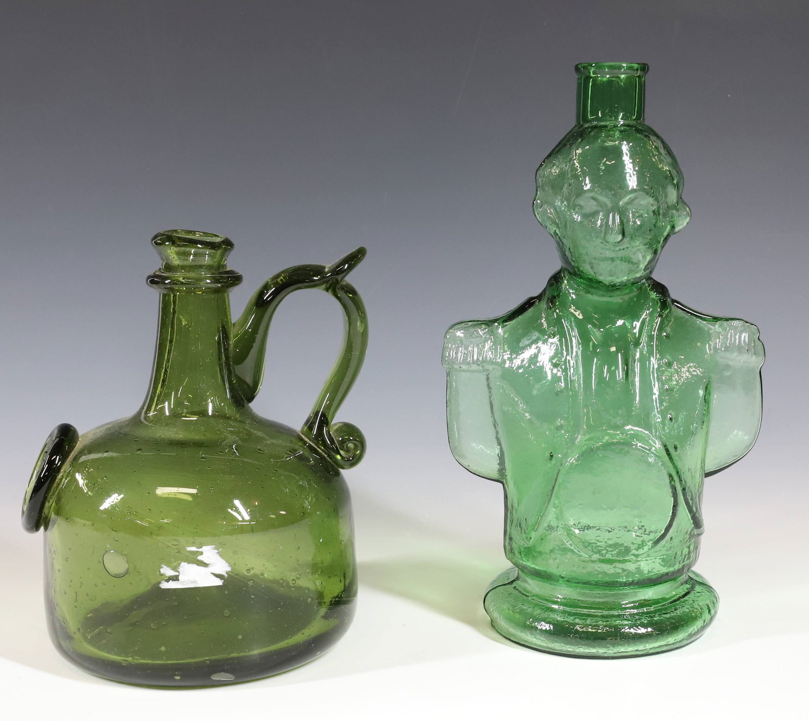 (2) REPLICA BOTTLES: CLEVENGER GREEN GEORGE WASHINGTON 9 1/2" H. AND JAMESTOWN BLOWN GLASS BOTTLE WITH APPLIED HANDLE AND SEAL IN OLIVE GREEN 7 1/4" H. PLEASE READ CAREFULLY - Terms for Purchasing and Shipping of Auction