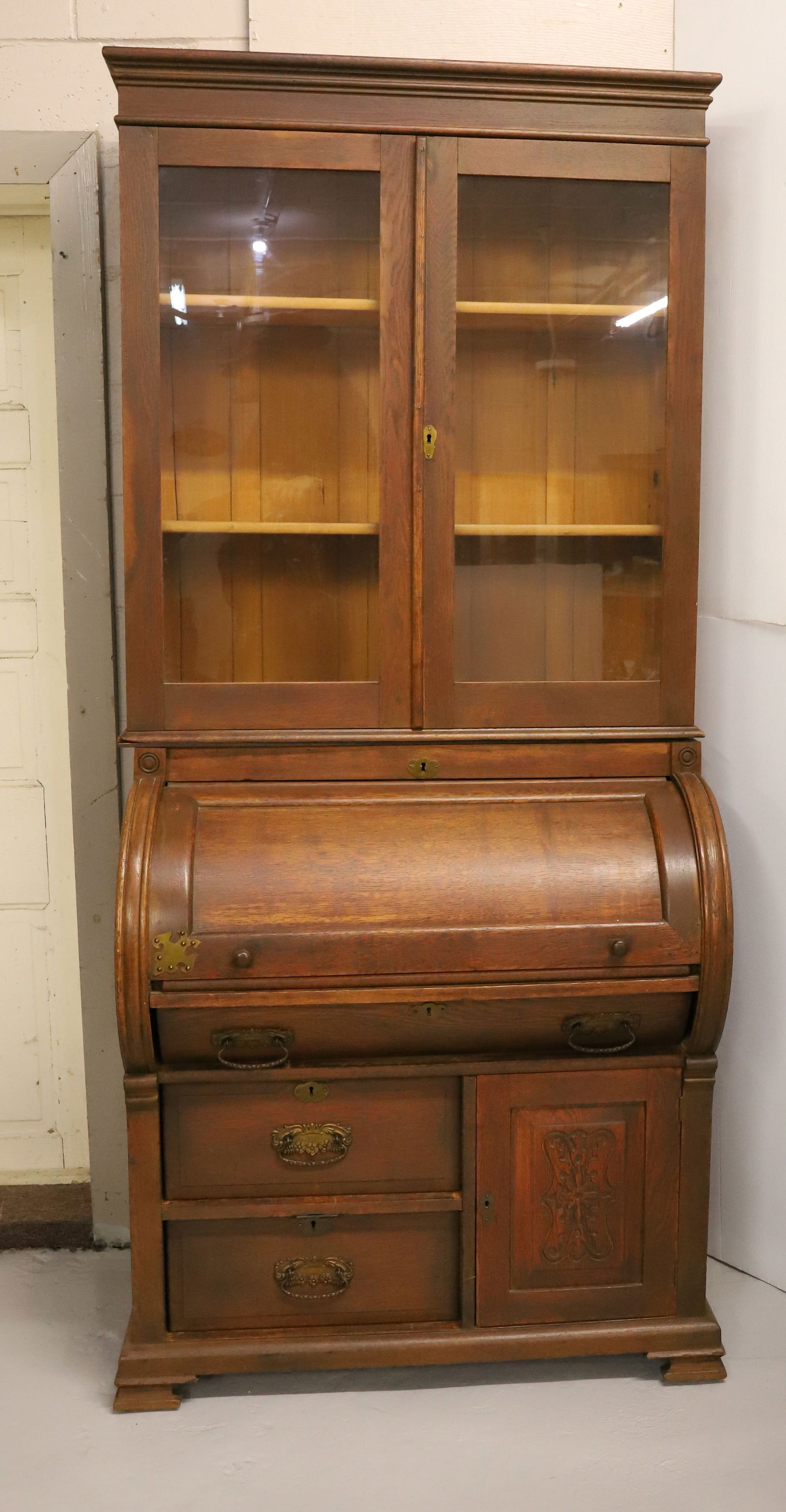 VICTORIAN CYLINDER DESK: TWO-PIECE DESK WITH TWO GLASS DOORS OVER CYLINDER DESK OVER THREE DRAWERS AND ONE DOOR. PULL-OUT WRITING SURFACE. PANELED ENDS. DIVIDED INTERIOR. BRASS HARDWARE. 82 1/2" X 36" X 21". PLEASE READ CAREF