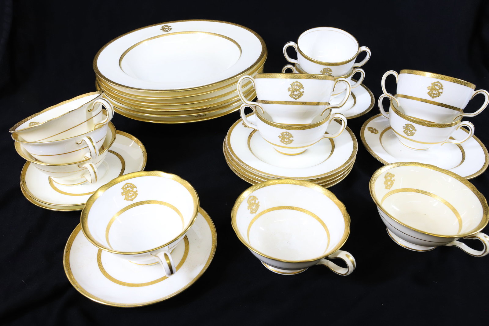 LOT OF MINTON BONE CHINA: GOLD TRIM WITH TWO DIFFERENT MONOGRAM STYLES. PINK GLOBE WITH CROWN STAMP. SOLD BY CILMAN, COLLAMORE & CO, NY. (6) SOUP PLATES 9 1/2" D. , (6) PLATES 6" D., (6) DOUBLE-HANDLE CUPS (ONE DAMAGED) WITH T