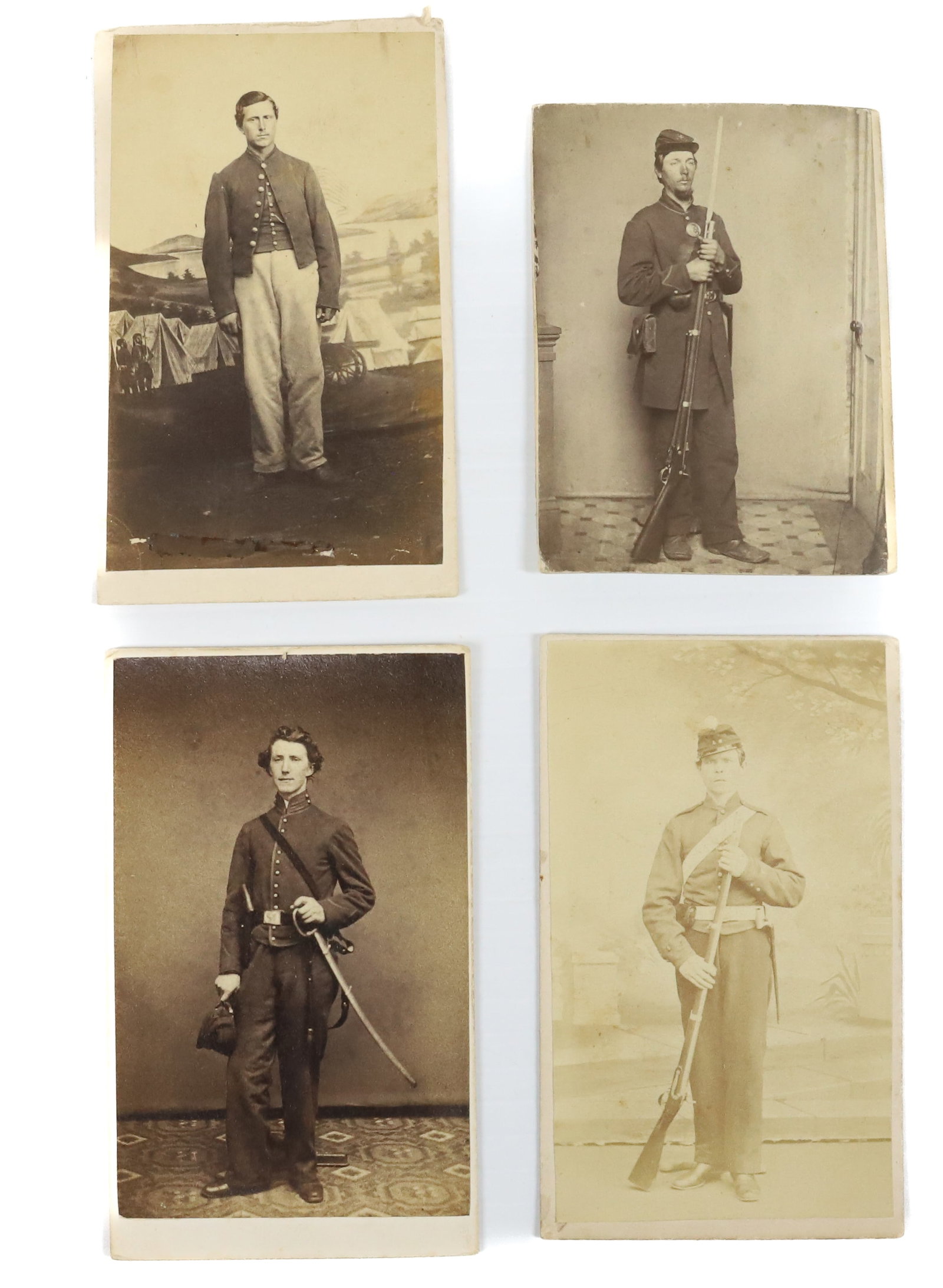 (4) CIVIL WAR SOLDIERS, CDVs: UNIDENTIFIED. STAMPED ON BACK "LEAMAN & LEE, READING, PA" (SOLDIER STANDING WITH MUSKET AND BAYONET), "ROBERTS, PHILADELPHIA" (HOLDING CAP IN HAND WITH OTHER HAND ON SWORD GRIP), "P. KELLMER'S, HAZLET