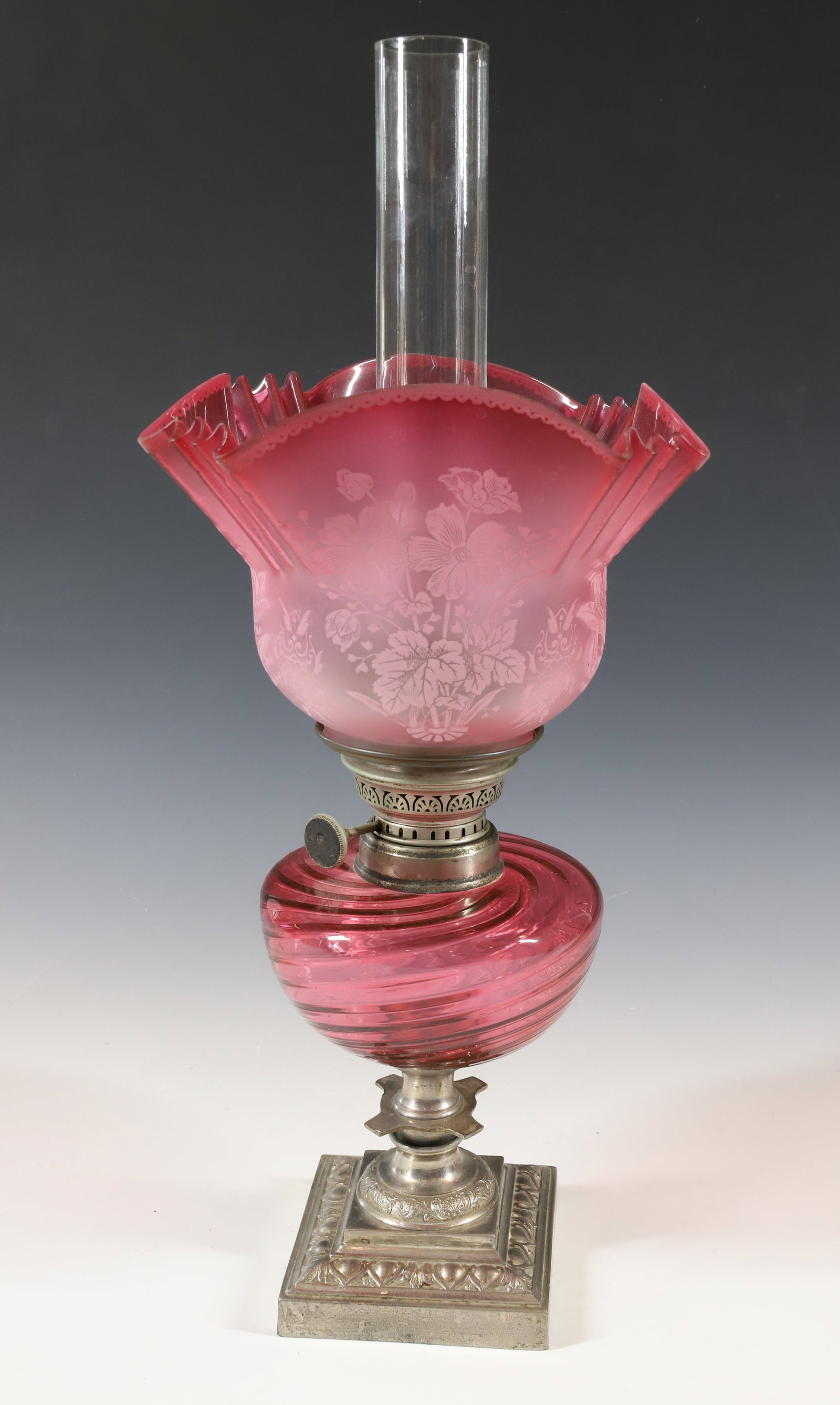CRANBERRY GLASS KEROSENE LAMP: CRANBERRY CASED SWIRLED FONT WITH CAST IRON NICKEL PLATE BASE SHADE WITH ART NOUVEAU FLORAL DECORATION ORIGINAL BURNER AND CHIMNEY 19 1/5" X 9 1/4" PLEASE READ CAREFULLY - Terms for Purchasing and Shi