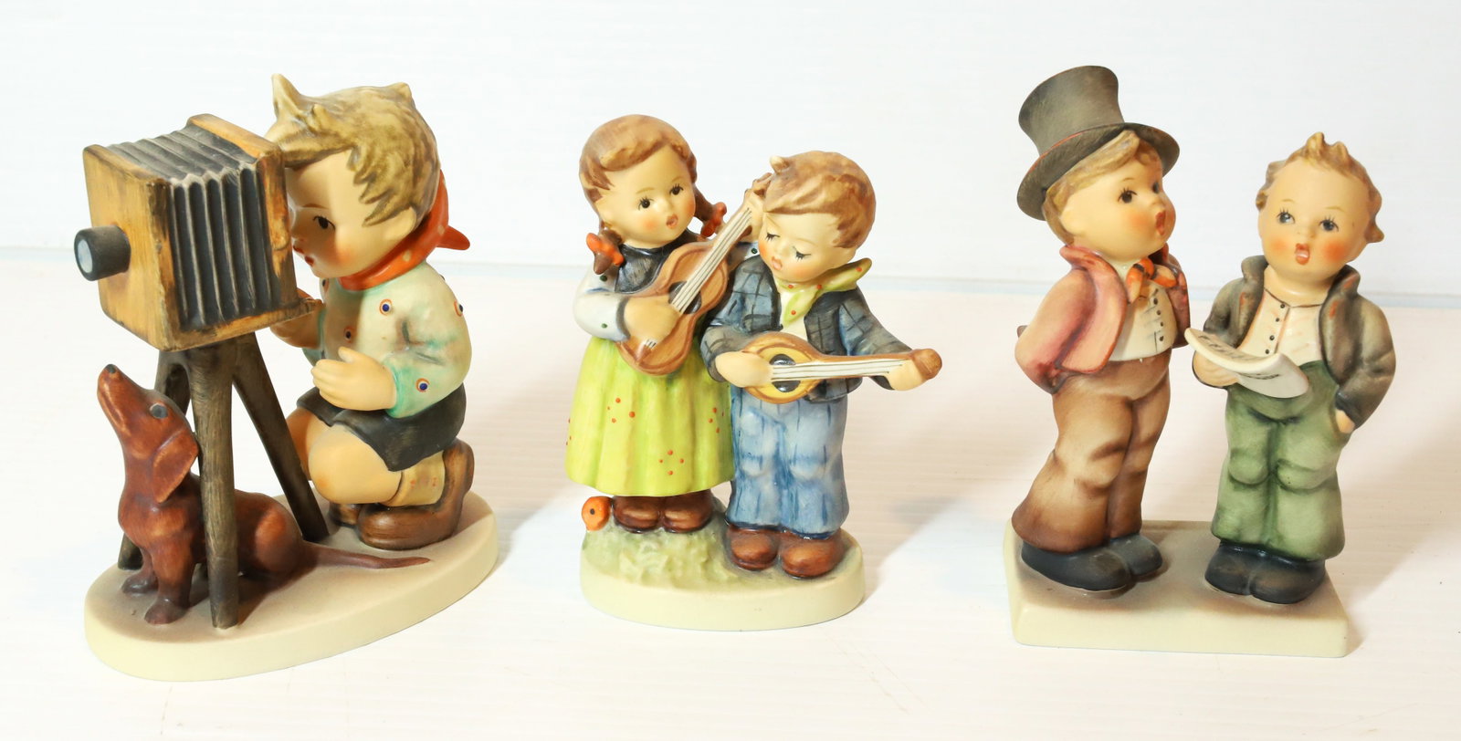 HUMMEL FIGURINES: THE PHOTOGRAPHER 5" H, HAPPY DAYS AND CAROLING BOYS. TMK-5 MARKS PLEASE READ CAREFULLY - Terms for Purchasing and Shipping of Auction Items. Please read carefully before bidding. All payments for purc