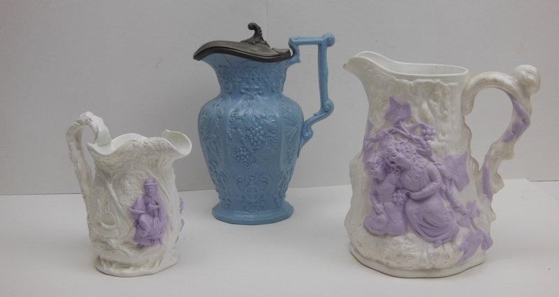 Parianware 3 Pitchers - Lavender, White & Blue. 19: 7 3/4" tall lavender & white Romantic Relief. Chips to pour rim. 5 3/8" tall lavender & white Alcock & Co. NO Damage. 8" tall blue vintage pattern Britain Lid Registry MK