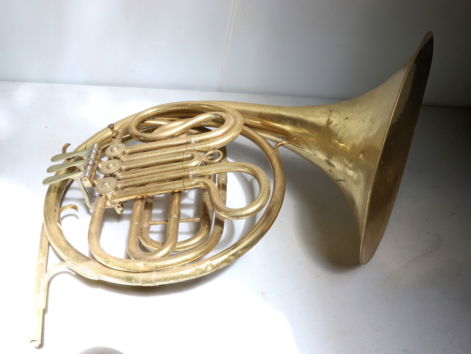 VINTAGE FRENCH HORN: BRASS. UNMARKED. NO MOUTHPIECE. 20" X 12". PLEASE READ CAREFULLY – THIS IS AN ONLINE ONLY AND ONSITE AUCTION. THE ADDRESS WILL BE GIVEN AFTER THE AUCTION HAS ENDED AND TO ALL SUCCESSFUL BIDDERS.