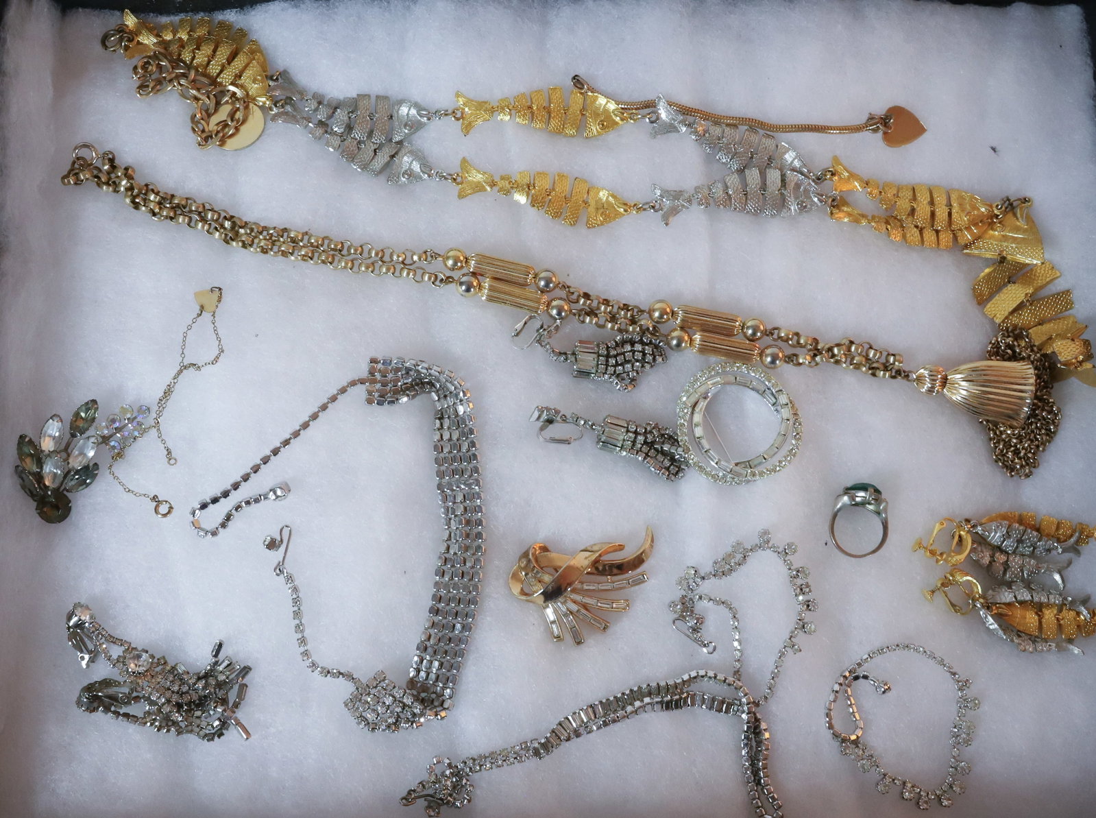 COSTUME JEWELRY: INCLUDES GOLD COLOR TRIFARI RHINESTONE BROOCH, FISH NECKLACE AND EARRINGS, RHINESTONE SETS, DROP EARRINGS, TASSEL NECKLACE AND OLD SILVER RING WORN STONE, 28"L, 24"L PLEASE READ CAREFULLY – THIS