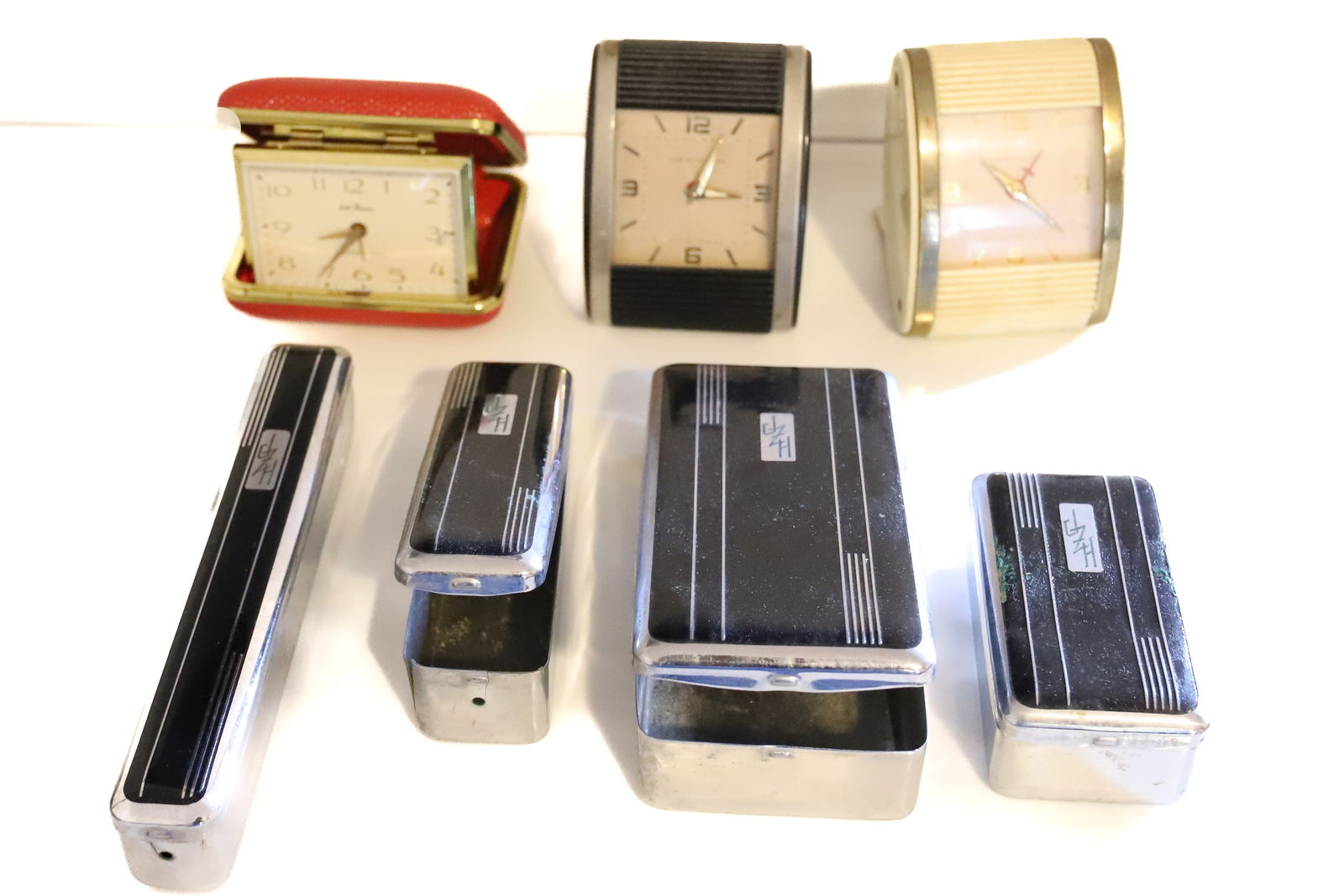 ART DECO TRAVEL SET/CLOCKS: (3) TRAVEL CLOCKS, (4) ART DECO CHROME TRAVEL CONTAINERS WITH BLACK AND MONOGRAM 3 1/2" TO 6 1/2" PLEASE READ CAREFULLY – THIS IS AN ONSITE ONLINE ONLY AUCTION. The Address is 206 Market St. Ban