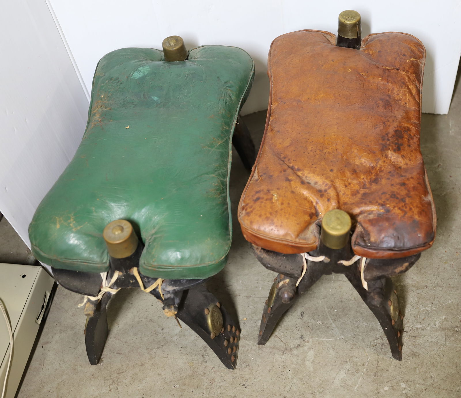 (2) LEATHER SADDLE HASSOCKS: RED LEATHER AND GREEN LEATHER WOOD BASES VINTAGE 14" X 20" X 12" PLEASE READ CAREFULLY – THIS IS AN ONSITE ONLINE ONLY AUCTION. The Address is 206 Market St. Bangor, Pa. 18013
