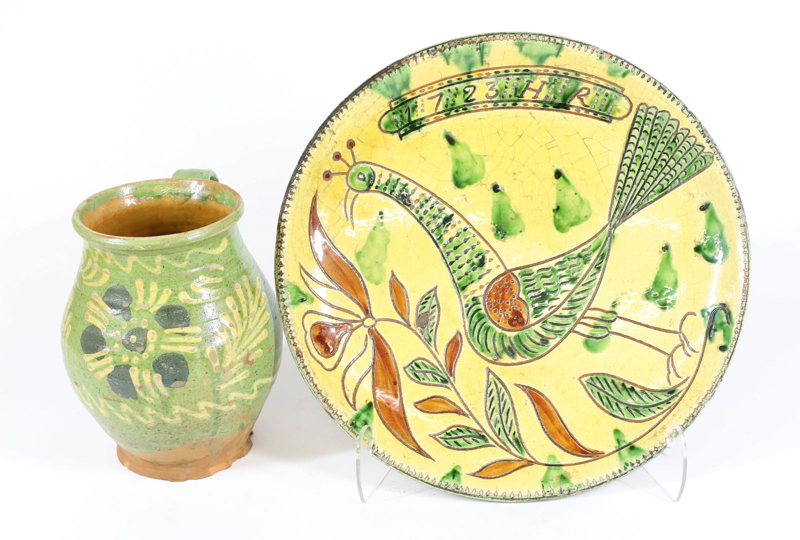 SGRAFFITO DECORATED PLATE: REDWARE POTTERY DECORATED WITH PEAFOWL AND DATED "1723, HR". MRKD. METROPOLITAN MUSEUM ON REVERSE. 12 3/4" D. WITH, POTTERY GLAZED POT. YELLOW AND GREEN DECORATION WITH SINGLE LOOP HANDLE. 7 1/2" H. P