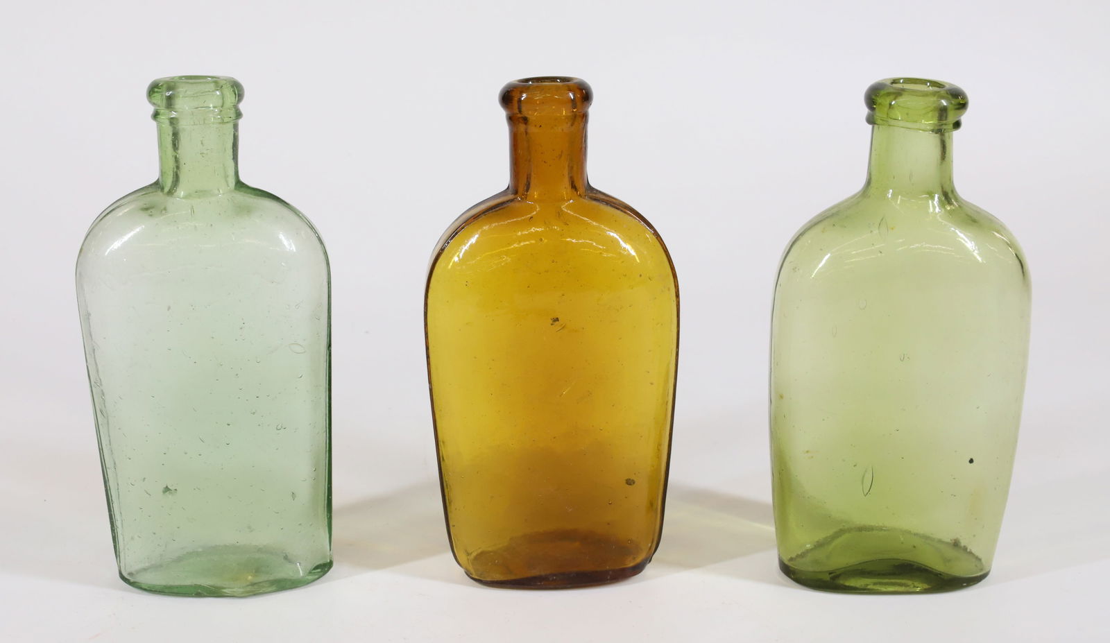 (3) 19TH C. FLASKS: AMBER AND TWO SHADES OF GREEN. ONE MRKD. "WARRANTED FLASK". 6" TO 6 1/4" HEIGHTS. PLEASE READ CAREFULLY - Terms for Purchasing and Shipping of Auction Items. Please read carefully before bidding. All