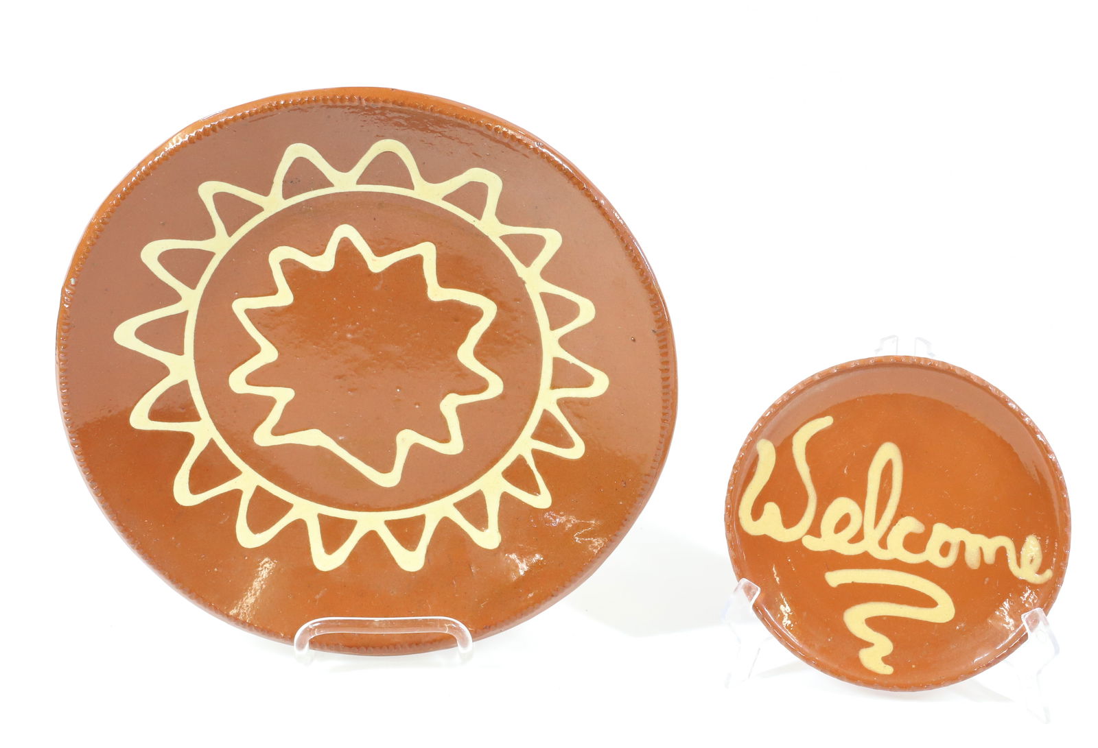 (2) CONTEMPORARY SLIP GLAZE REDWARE PLATES: WELCOME AND SUN PATTERN. 6 1/2" TO 11 3/4" DIAMETERS. PLEASE READ CAREFULLY - Terms for Purchasing and Shipping of Auction Items. Please read carefully before bidding. All payments for purchases will