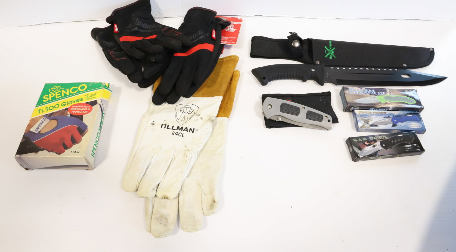 BOX OF GLOVES AND KNIVES: MILWAUKEE GLOVES, 5 KNIVES Terms: THIS SALE IS AN ONLINE ONLY TOOL AND EQUIPMENT AUCTION. PLEASE READ CAREFULLY..... THERE ARE (2) LOCATIONS FOR THE ITEMS LISTED: LOTS 1 TO 286 ARE LOCATED AT 15 NEW H