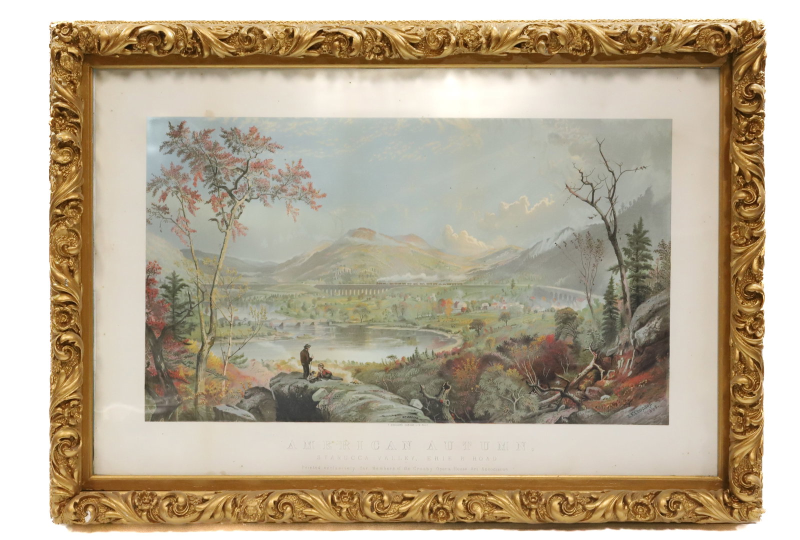 T. SINCLAIR CHROMOLITHOGRAPH "AMERICAN AUTUMN": TITLED "AMERICAN AUTUMN, STARRUCCA VALLEY, ERIE R. ROAD" PRINTED EXCLUSIVELY FOR MEMBERS OF THE CROSBY OPERA HOUSE ART ASSOCIATION. ORNATE FRAME. SIGHT VIEW 20 3/4" X 31 3/4". TOTAL SIZE 25 3/4" X 36 