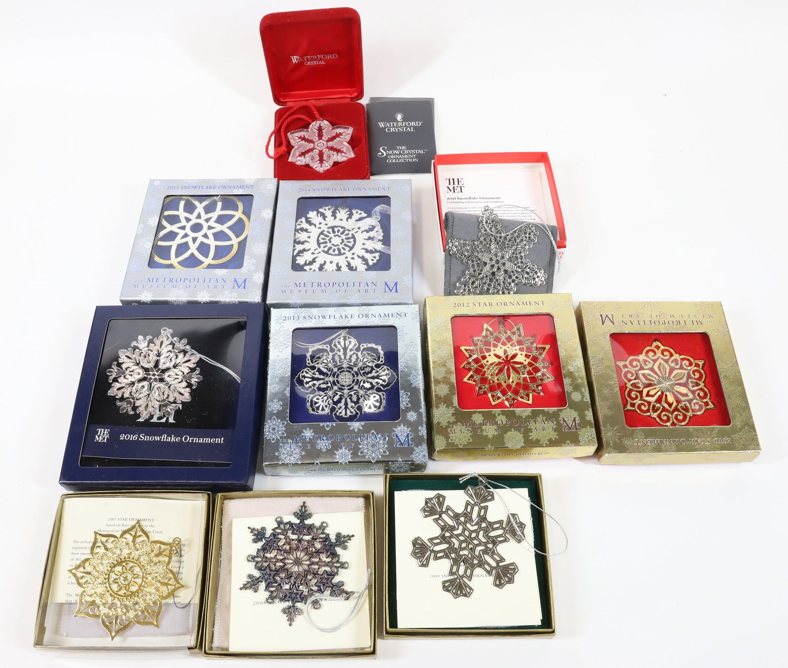METROPOLITAN MUSEUM CHRISTMAS ORNAMENTS: (10) ORNAMENTS IN BOXES (2007-2010, 2012-2016, 2021). WITH WATERFORD CRYSTAL ORNAMENT 1996. PLEASE READ CAREFULLY -THIS IS AN ONLINE ONLY AUCTION. WE WILL BE TAKING ABSENTEE AND PHONE BIDS ALSO. Terms