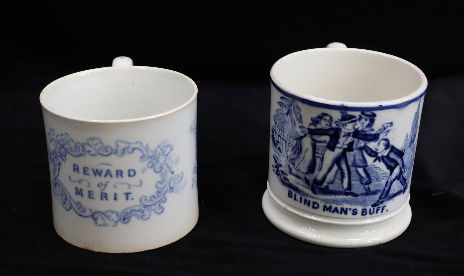 (2) CHILD'S TRANSFERWARE MUGS: BLIND MAN'S BLUFF AND "REWARD OF MERIT". 2 1/2" AND 2 3/4" HEIGHTS. PLEASE READ CAREFULLY - Terms for Purchasing and Shipping of Auction Items. Please read carefully before bidding. All payments for p