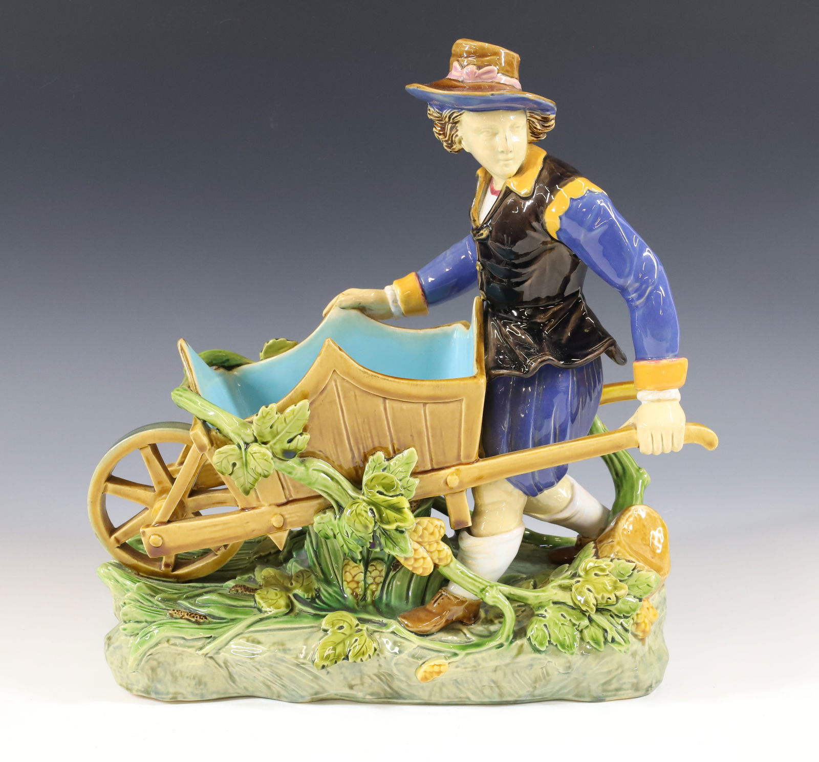 MINTON MAJOLICA FIGURINE: MAN WITH WHEELBARROW BRIGHT MAJOLICA COLORS MINTON ON BASE WITH CYPHERS, #413, 13"H X 12" X 6" PLEASE READ CAREFULLY - Terms for Purchasing and Shipping of Auction Items. Please read carefully before