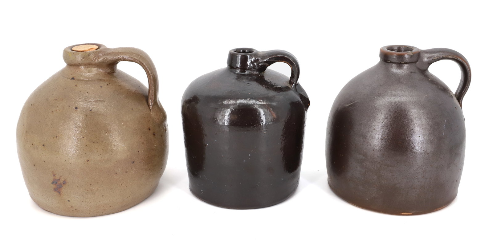 (3) STONEWARE JUGS: BROWN AND TAN GLAZES. 7 1/2" HEIGHTS. PLEASE READ CAREFULLY - Terms for Purchasing and Shipping of Auction Items. Please read carefully before bidding. All payments for purchases will be made through 