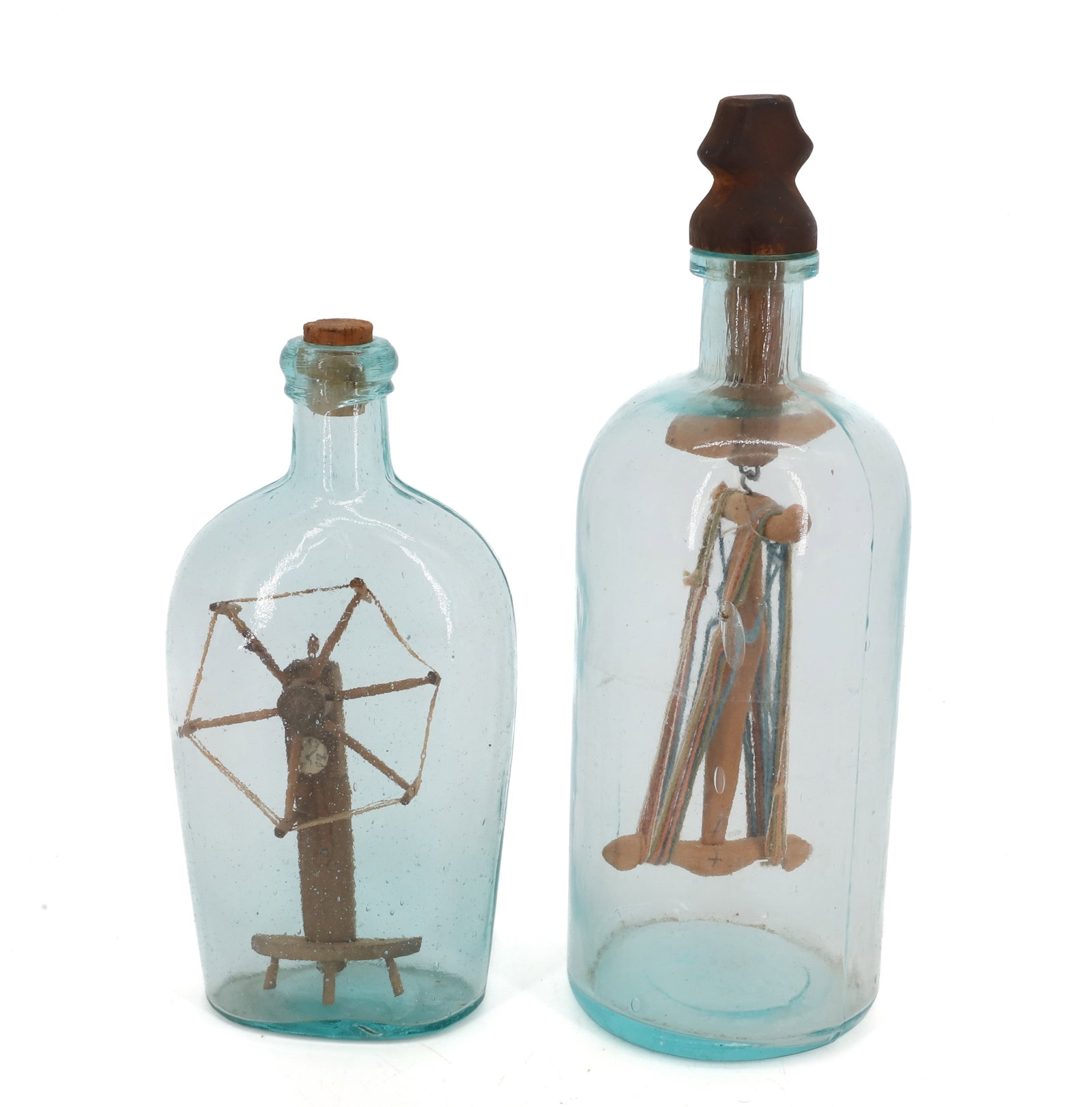 (2) VINTAGE BOTTLE WHIMSEYS: SPINNING WHEEL AND NIDDY-NODDER IN BOTTLES. LARGER HAS CARVED STOPPER. 7 3/4" AND 10 1/4" HEIGHTS. PLEASE READ CAREFULLY - Terms for Purchasing and Shipping of Auction Items. Please read carefully bef