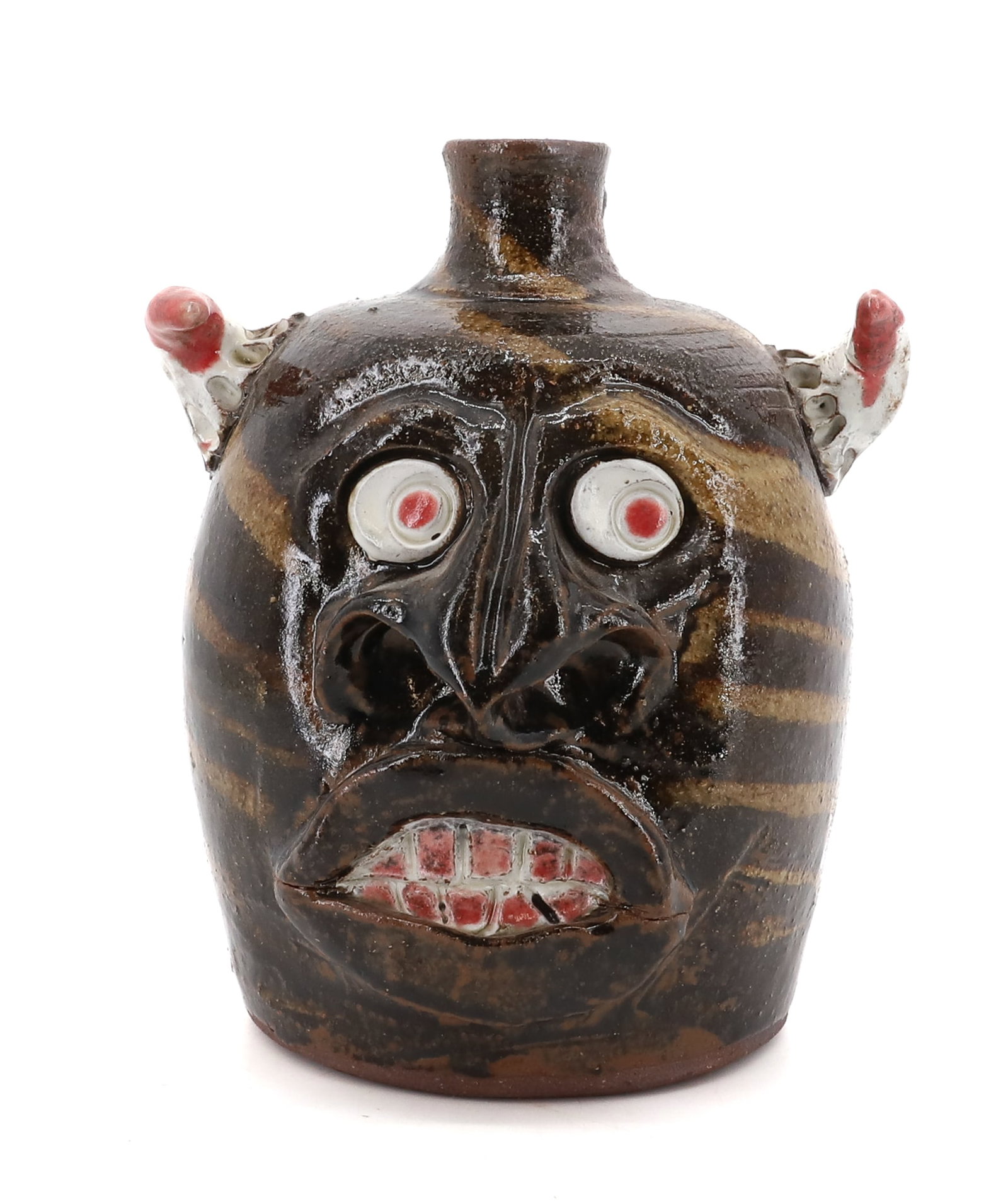 MIKE HANNING POTTERY FACE JUG: BROWN/TAN GLAZE WITH WHITE AND RED HIGHLIGHTS. SGND. ON BOTTOM. DATED 1999. 7 1/2" H. PLEASE READ CAREFULLY - Terms for Purchasing and Shipping of Auction Items. Please read carefully before bidding. 