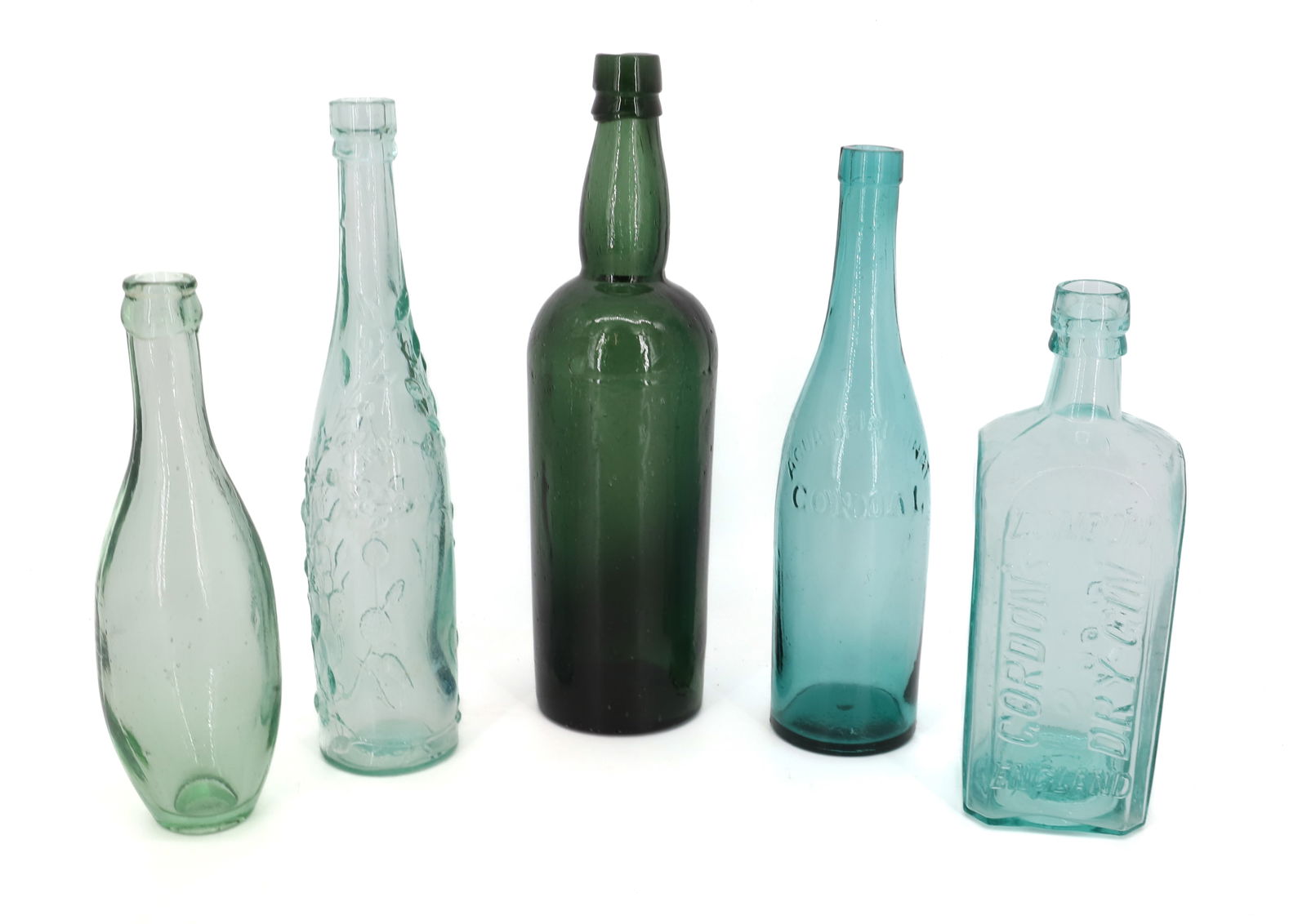 LOT OF ANTIQUE BOTTLES: (5) INCLUDING: EMBOSSED FLORAL BOTTLE, "AQUA DE RUBINAT CORDIAL", "GORDON'S DRY GIN" AND MORE. 8 3/4" TO 11 3/4" HEIGHTS. PLEASE READ CAREFULLY - Terms for Purchasing and Shipping of Auction Items. Pl
