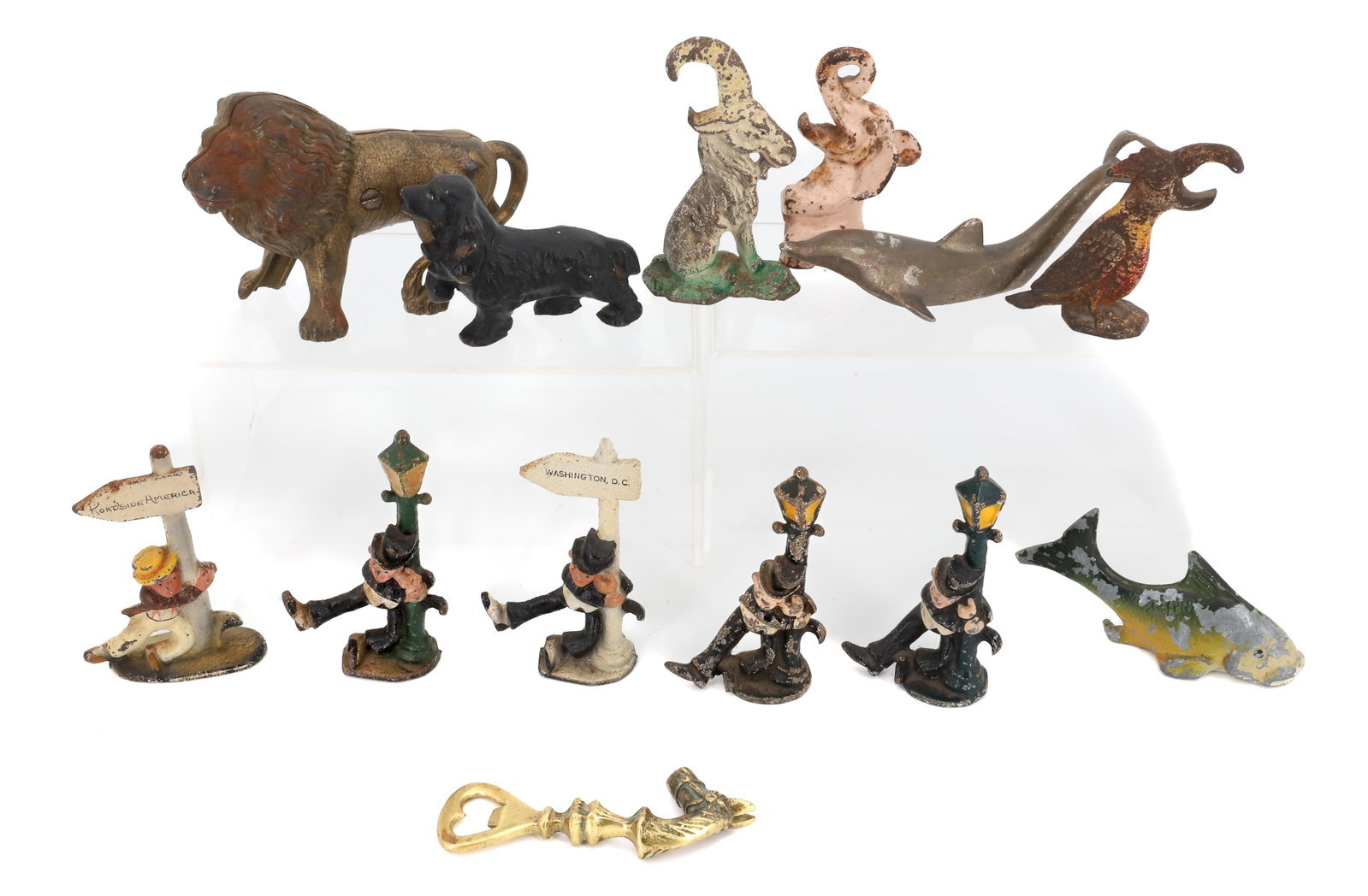 LOT OF CAST IRON / BRASS BOTTLE OPENERS: PAINTED CAST IRON OPENERS (DRUNKEN MAN WITH LIGHT POST OR SIGN PARROT, FISH GOAT) , BRASS OPENERS AND LION STILL BANK 5 1/2" L. PLEASE READ CAREFULLY - Terms for Purchasing and Shipping of Auction Ite