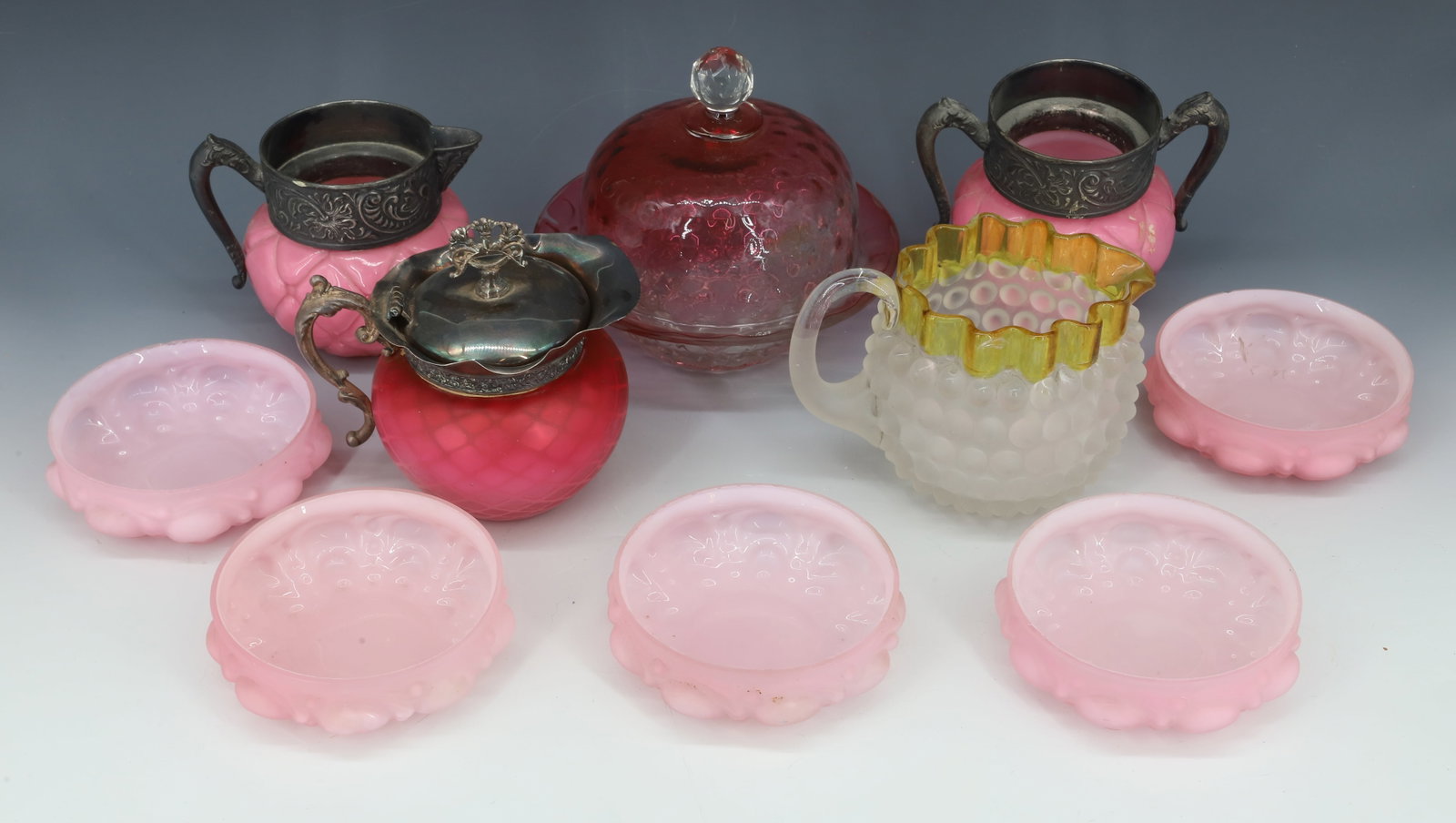(9) VICTORIAN ART GLASS: INCLUDES (4) CASED PINK BERRY BOWLS, PINK CASED SUGAR,CREAMER , SATIN HOBNAIL CREAMER WITH AMBER RIM, CRANBERRY BUTTER DISH, AND DIAMOND QUILTED RED SATIN CREAMER BOWLS 1 1/2"H, OTHER 4" TO 6"H PLEASE