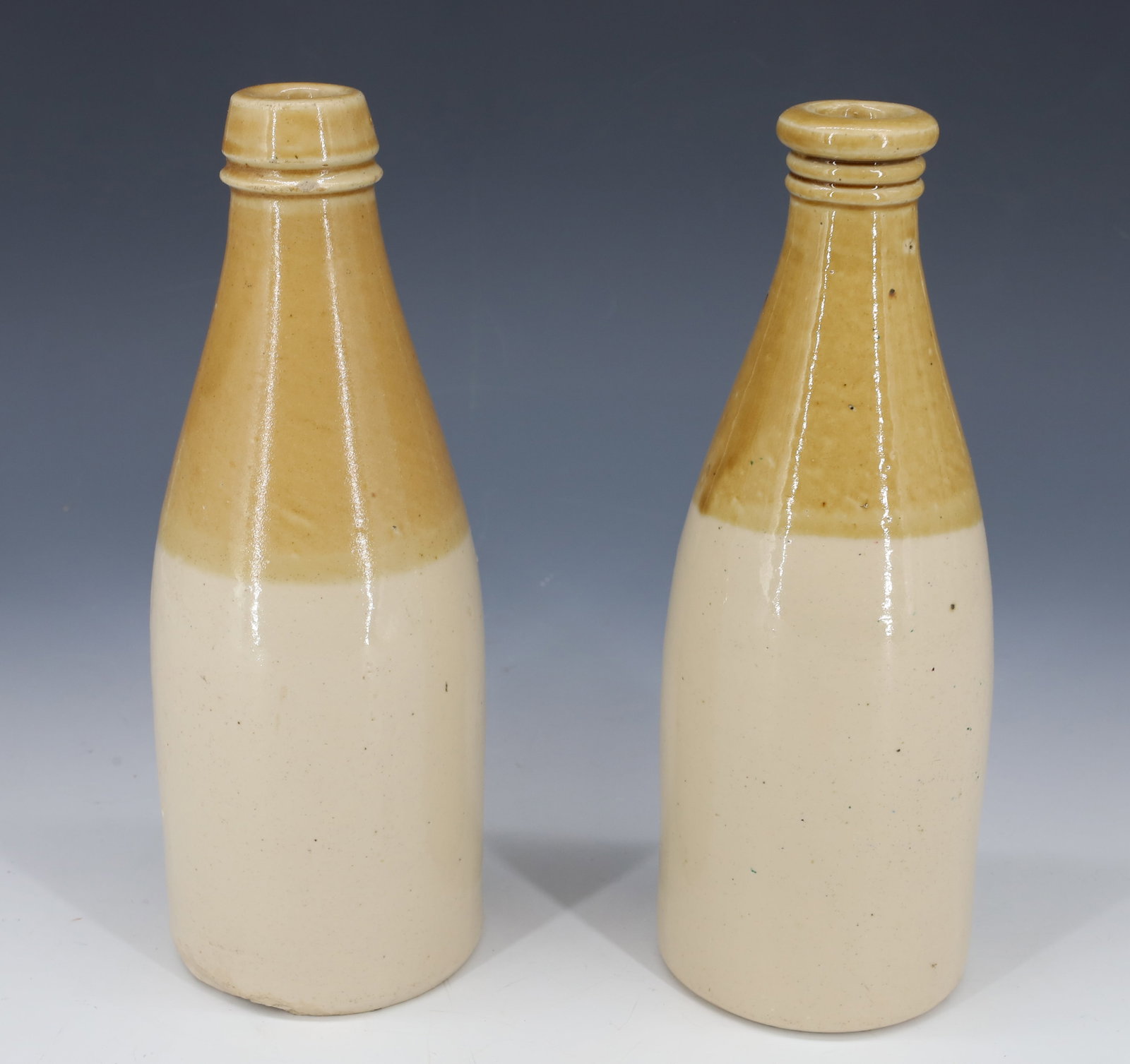 (2) ANTIQUE STONEWARE BOTTLES: TAN AND OFF WHITE GLAZE RINGS AT LIP 8 1/2" PLEASE READ CAREFULLY - Terms for Purchasing and Shipping of Auction Items. Please read carefully before bidding. All payments for purchases will be made th