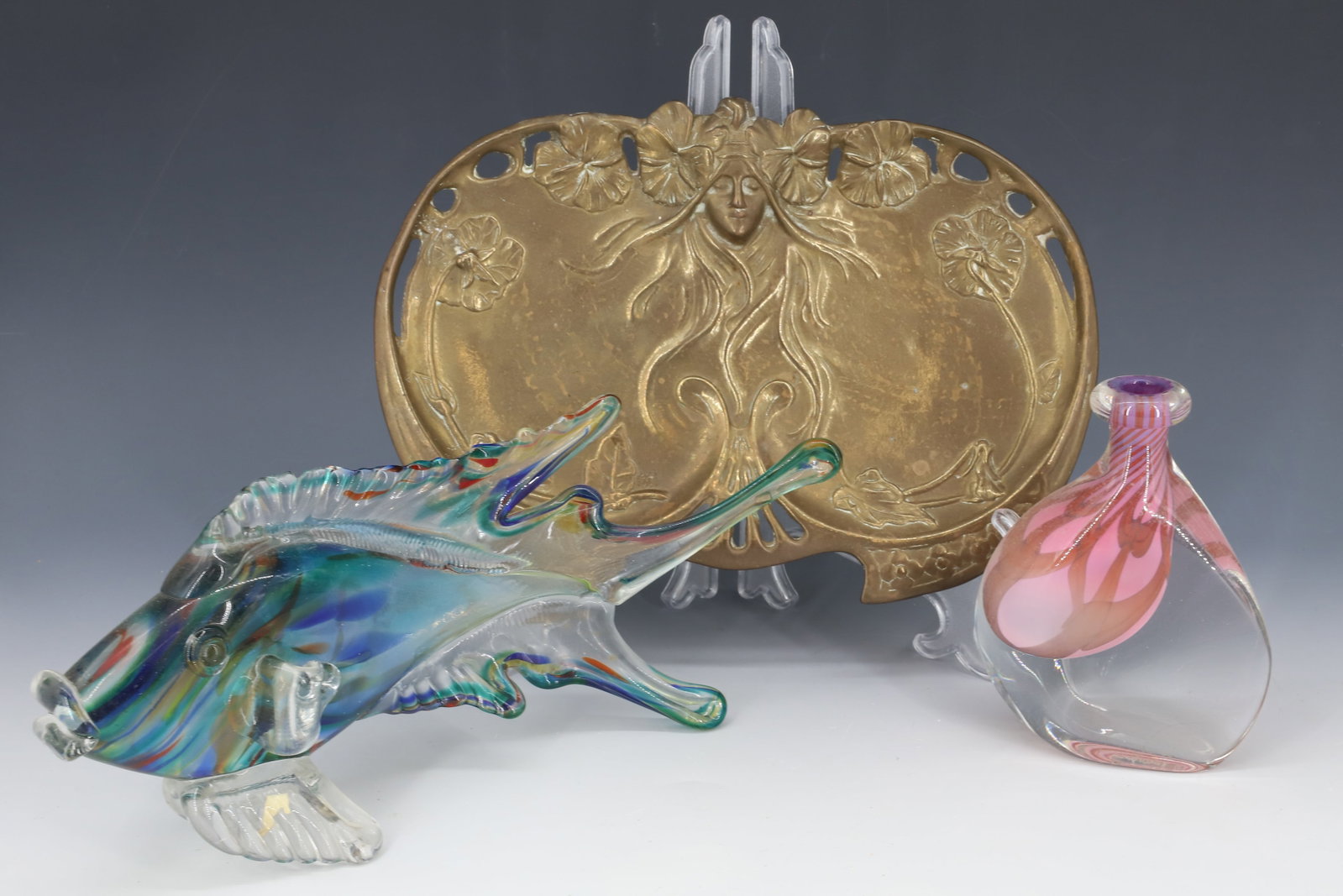 (3) ART NOUVEAU BRASS , ART GLASS: NOUVEAU BRASS TRAY WOMAN WITH FLOWING HAIR, ITALIAN BLOWN GLASS FISH SCULPTURE AND FINNISH ART GLASS BOTTLE 7 3/4" X 11 1/4" PLEASE READ CAREFULLY - Terms for Purchasing and Shipping of Auction Items.