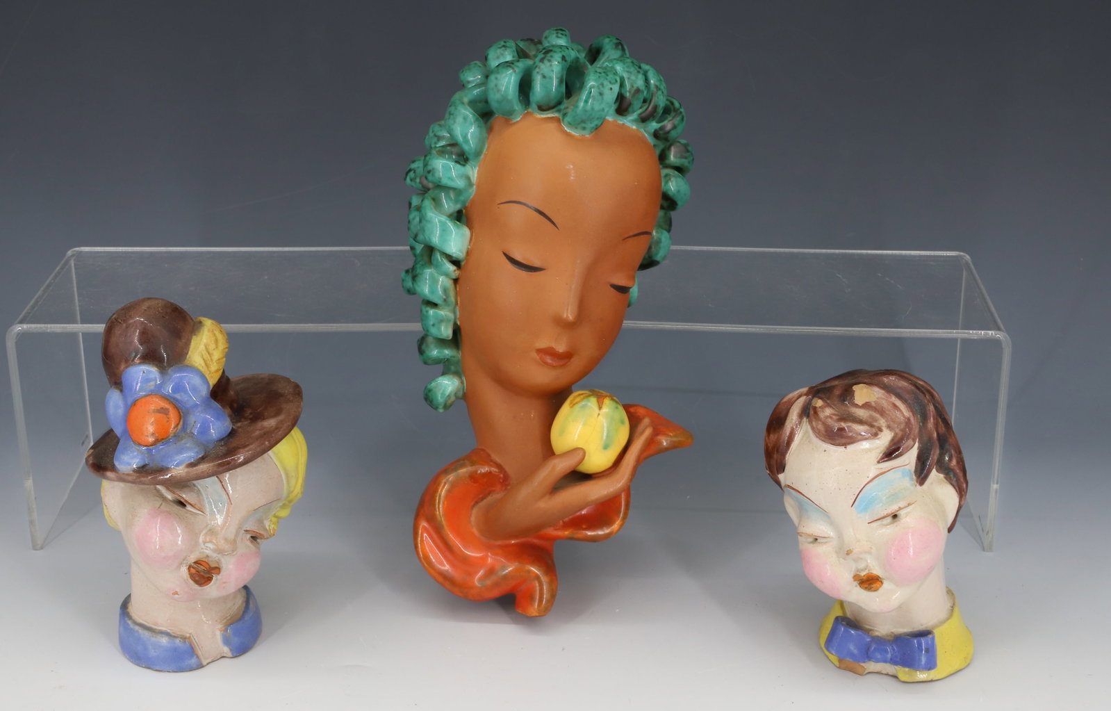 VINTAGE GOLDSCHEIDER STYLE MASK AND MARIA H. RAHMER POTTERY: GOLDSCHEIDER STYLE POTTERY MASK UNMARKED, MARIA H RAHMER GIRL WITH FLOWER HAT AND BOY WITH BOWTIE ONE PAPER LABEL BOTH STAMPED 9" X 4", 5 1/2"H,4 1/2"H PLEASE READ CAREFULLY - Terms for Purchasing and