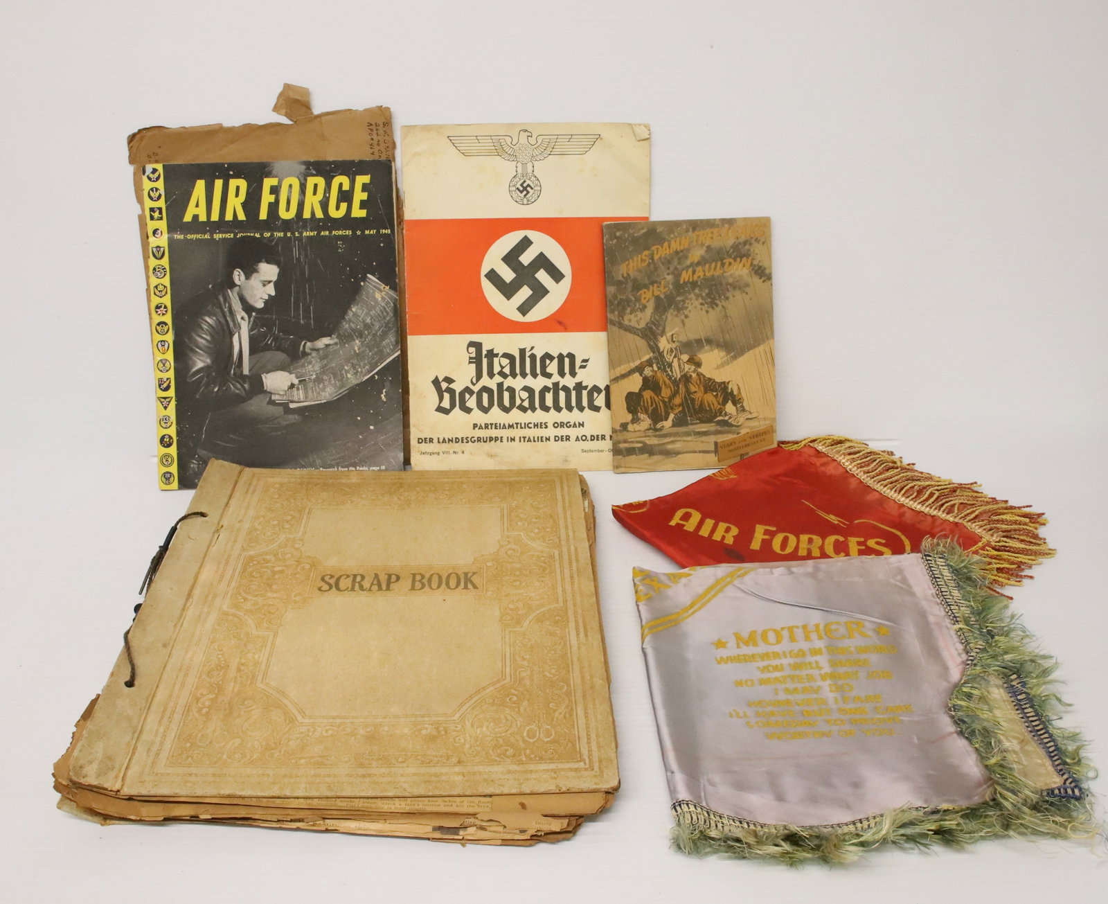 LOT OF MILITARY ITEMS: INCLUDING: SILK PILLOW COVERS, 1945 WAR CARTOONS BOOK, 1944 ITALIAN/GERMAN BOOKLET, NEWSPAPER CLIPPING SCRAPBOOK AND MORE. Terms: PLEASE READ CAREFULLY - Terms for Purchasing and Shipping of Auction I