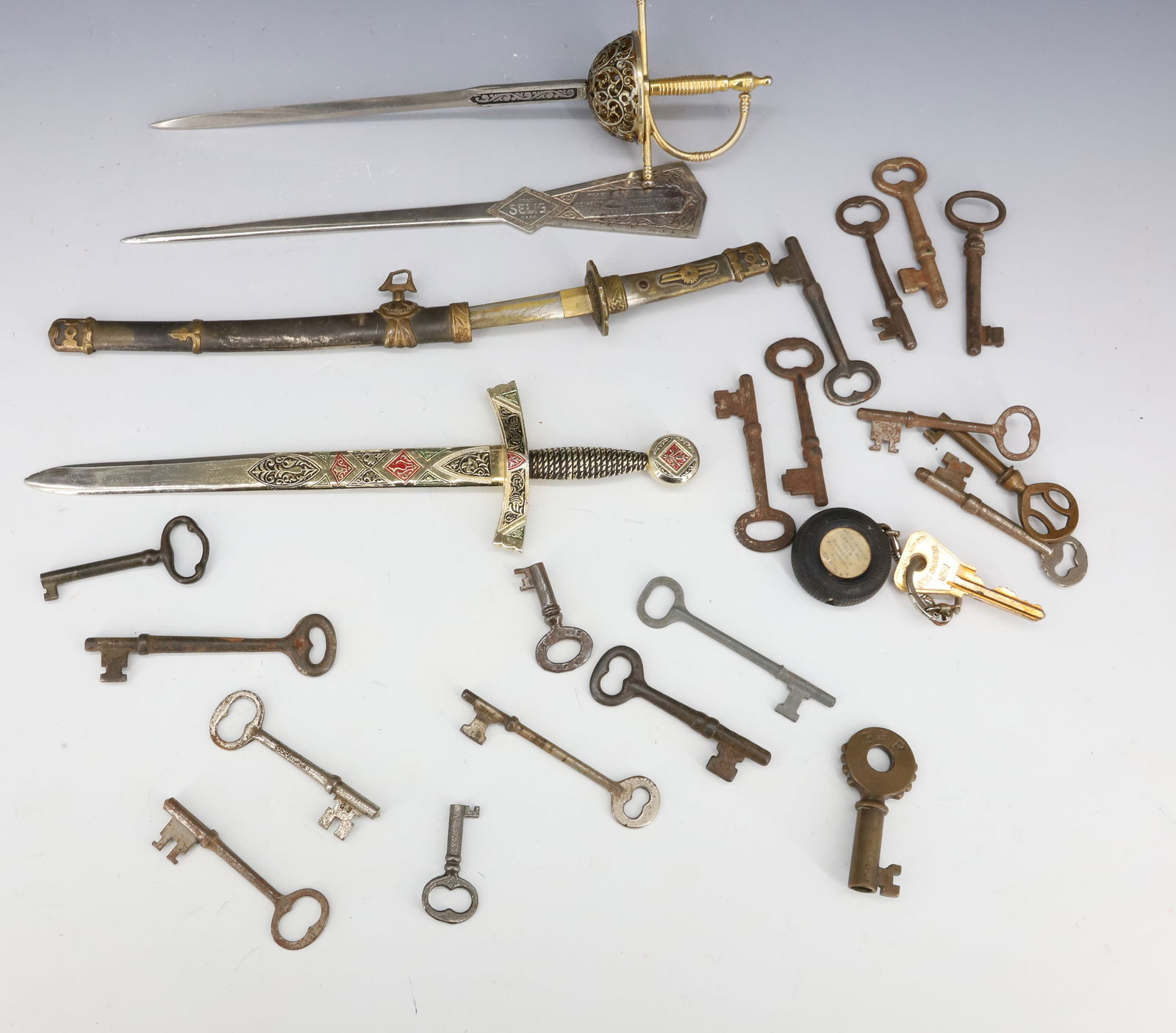 LOT OF KEYS AND LETTER OPENERS: VARIOUS BRASS/METAL KEYS WITH "SWORD" LETTER OPENERS. Terms: PLEASE READ CAREFULLY - Terms for Purchasing and Shipping of Auction Items. Please read carefully before bidding. All payments for purchase