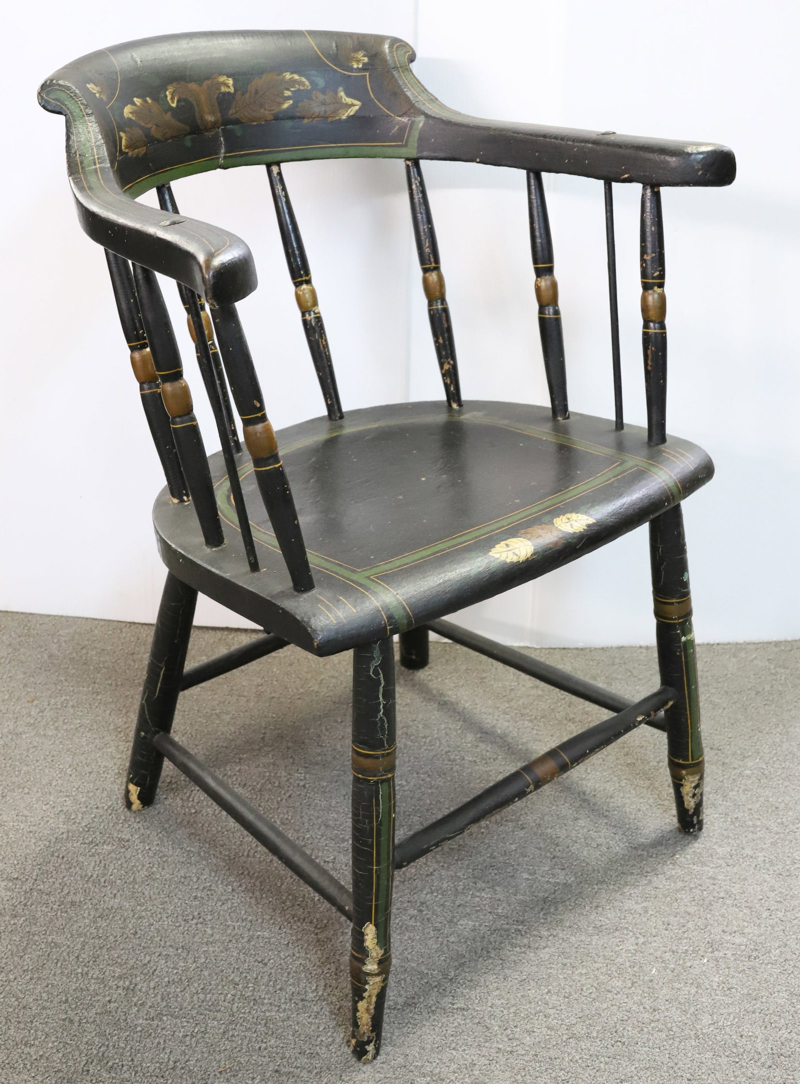 PAINT DECORATED CAPTAIN'S CHAIR: BLACK/GREEN/YELLOW WITH LEAF DECORATION ON BACK AND SEAT FRONT. 29 1/2" X 23" X 16 1/2". Terms: PLEASE READ CAREFULLY - Terms for Purchasing and Shipping of Auction Items. Please read carefully before