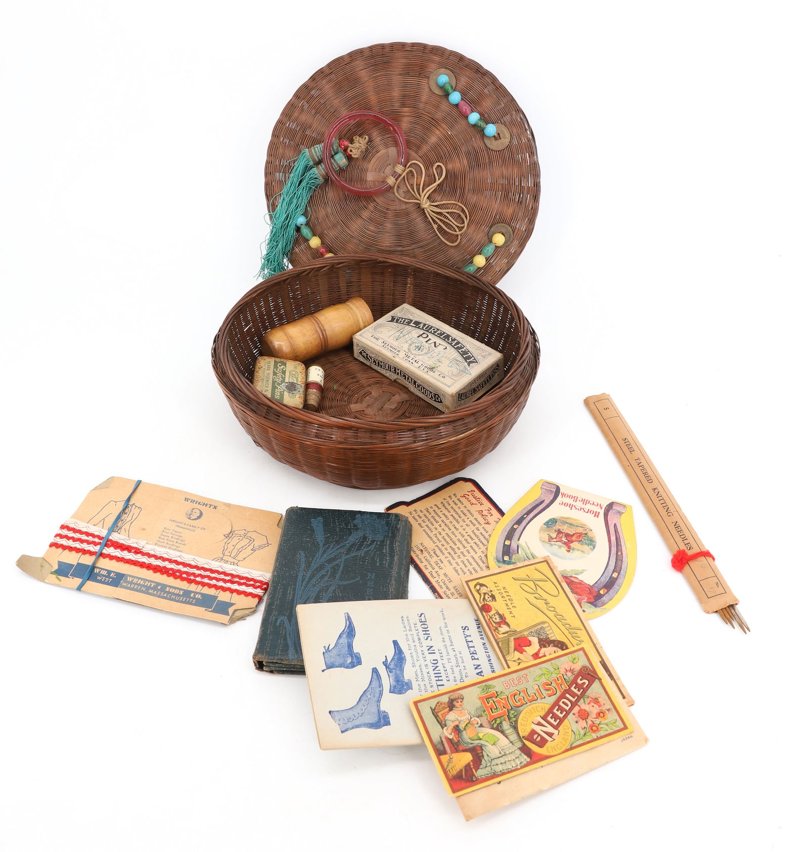 VINTAGE SEWING BASKET WITH CONTENTS: WOVEN LIDDED BASKET WITH ADVERTISING NEEDLE PACKETS, PINS, THIMBLE AND MORE. 10" D. PLEASE READ CAREFULLY - Terms for Purchasing and Shipping of Auction Items. Please read carefully before bidding. Al
