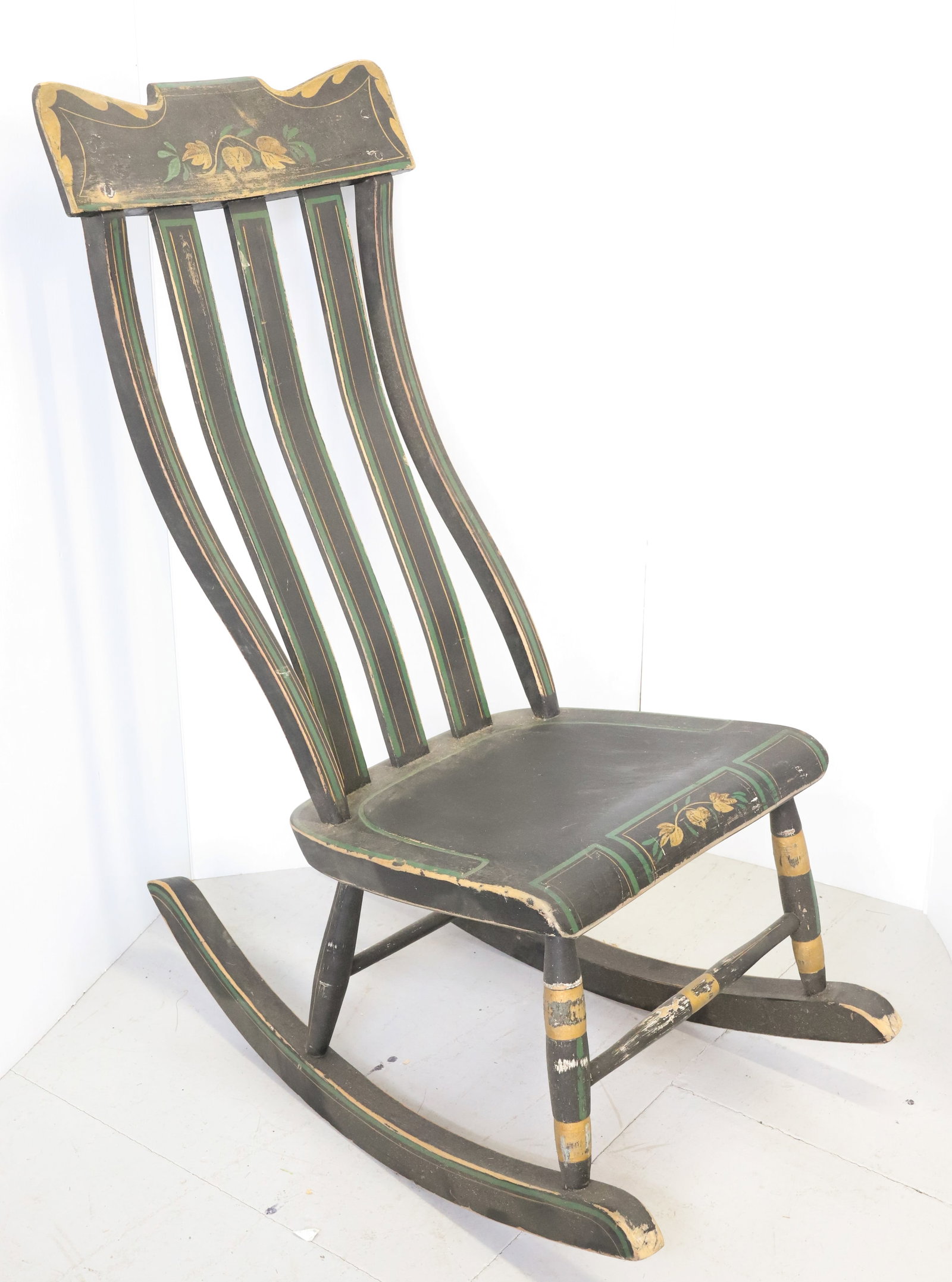 19TH C. PAINT DECORATED ROCKING CHAIR: BLACK/GREEN YELLOW. UNUSUAL STYLE BACK. 40" TOTAL HEIGHT. PLEASE READ CAREFULLY - Terms for Purchasing and Shipping of Auction Items. Please read carefully before bidding. All payments for purchases w
