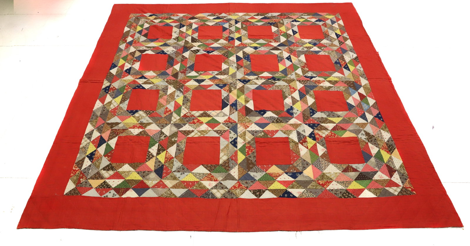 VINTAGE HAND STITCHED QUILT: RED SQUARE AND TRIANGLE PATTERNS. THIN BATTING. FLORAL BACKING. 84" X 84". PLEASE READ CAREFULLY - Terms for Purchasing and Shipping of Auction Items. Please read carefully before bidding. All payment