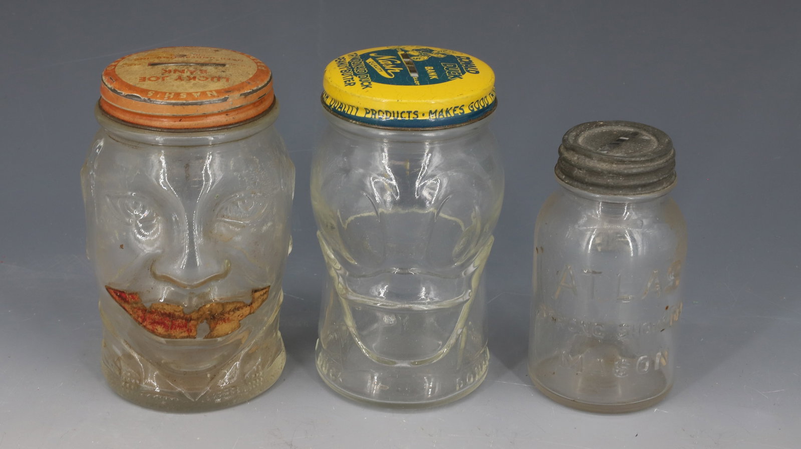 LOT OF GLASS STILL BANKS: (3) INCLUDING; DONALD DUCK PEANUT BUTTER, NASH'S MUSTARD, AND ATLAS MASON JAR - 3 3/4" TO 4 1/2" H PLEASE READ CAREFULLY - Terms for Purchasing and Shipping of Auction Items. Please read carefully bef