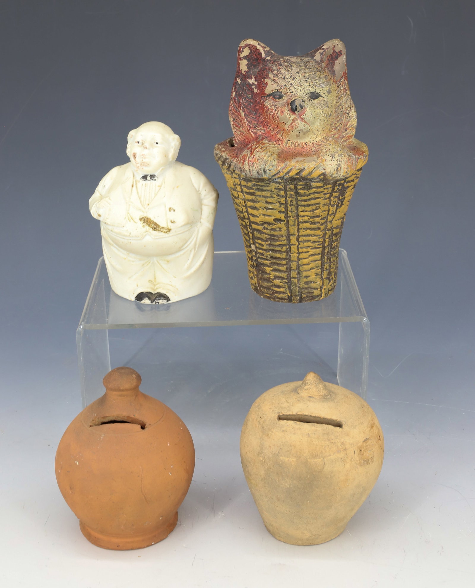 LOT OF POTTERY BANKS: (4) BANKS INCLUDING; CAT IN BASKETS CHALKWARE BANK ( 5 1/4" H), JOHN BULL MOLDED BANK MARKED 1847 ON BOTTOM, AND (2) BULBOUS PENNY BANKS PLEASE READ CAREFULLY - Terms for Purchasing and Shipping of Au