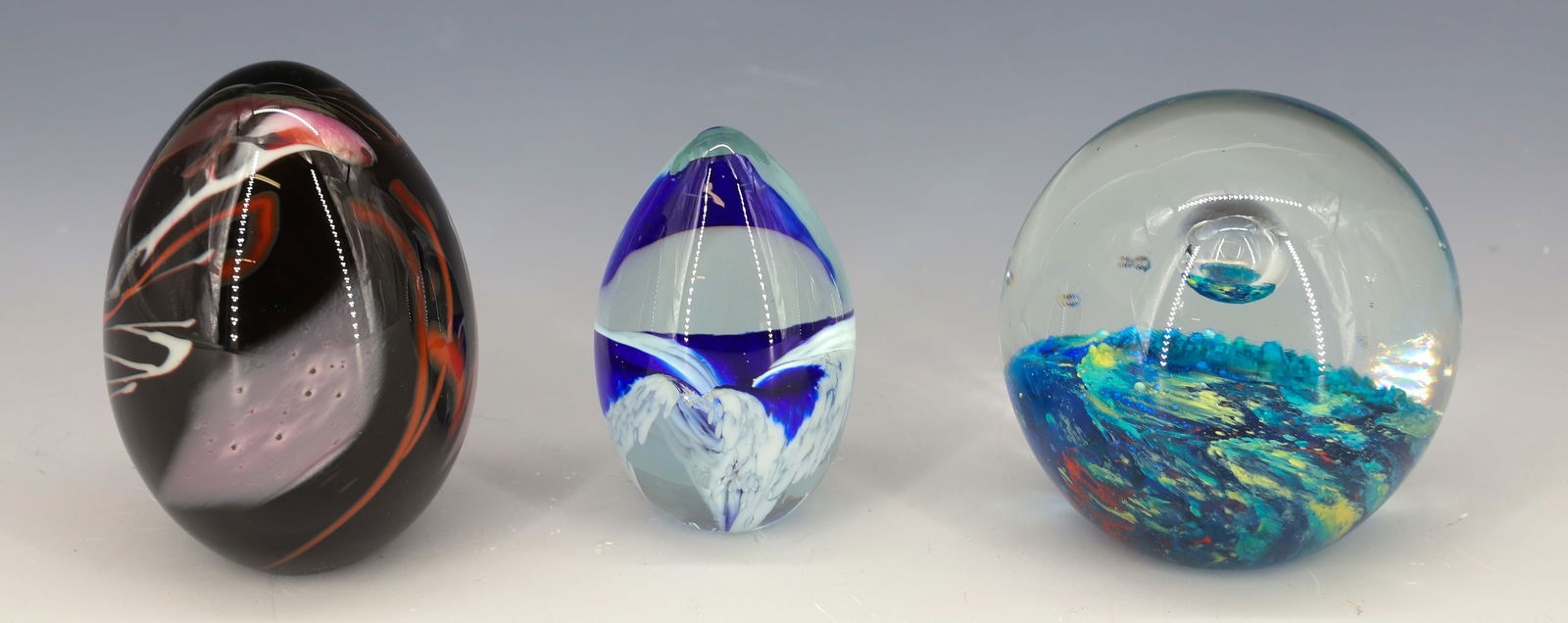 (3) ART GLASS PAPERWEIGHTS: (2) EGG SHAPED SIGNED MHS 1989 AND CONTROLLED BUBBLE WITH BLUE LAVA BASE 2 1/2"H,3 1/4"H,3"H PLEASE READ CAREFULLY - Terms for Purchasing and Shipping of Auction Items. Please read carefully before bi