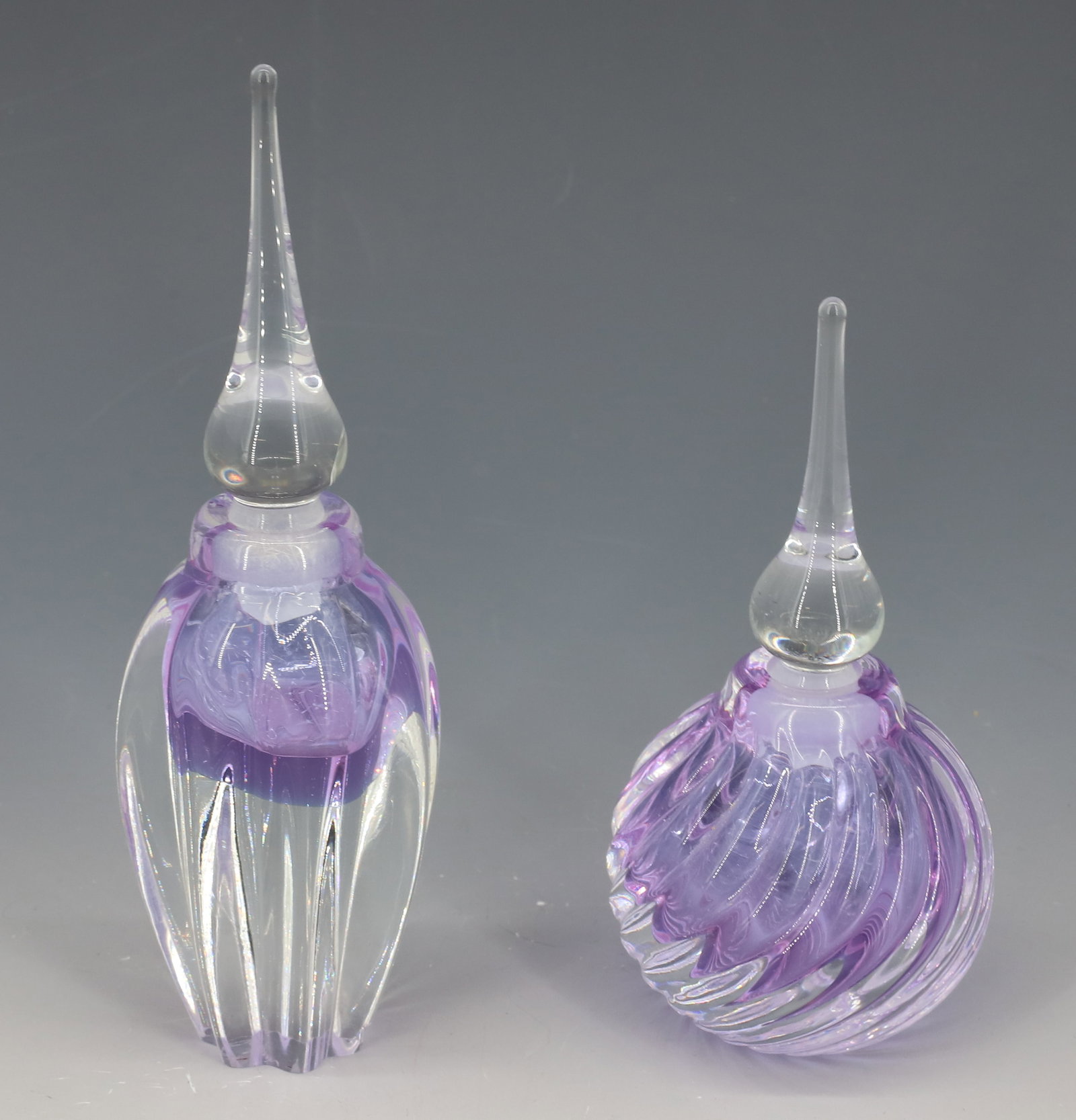(2) SIGNED ART GLASS PERFUME BOTTLES: BOTH SIGNED VANDERMARK, STEEPLE STOPPERS LIGHT LAVENDER 5 1/4"H,6 1/2"H PLEASE READ CAREFULLY - Terms for Purchasing and Shipping of Auction Items. Please read carefully before bidding. All payments f