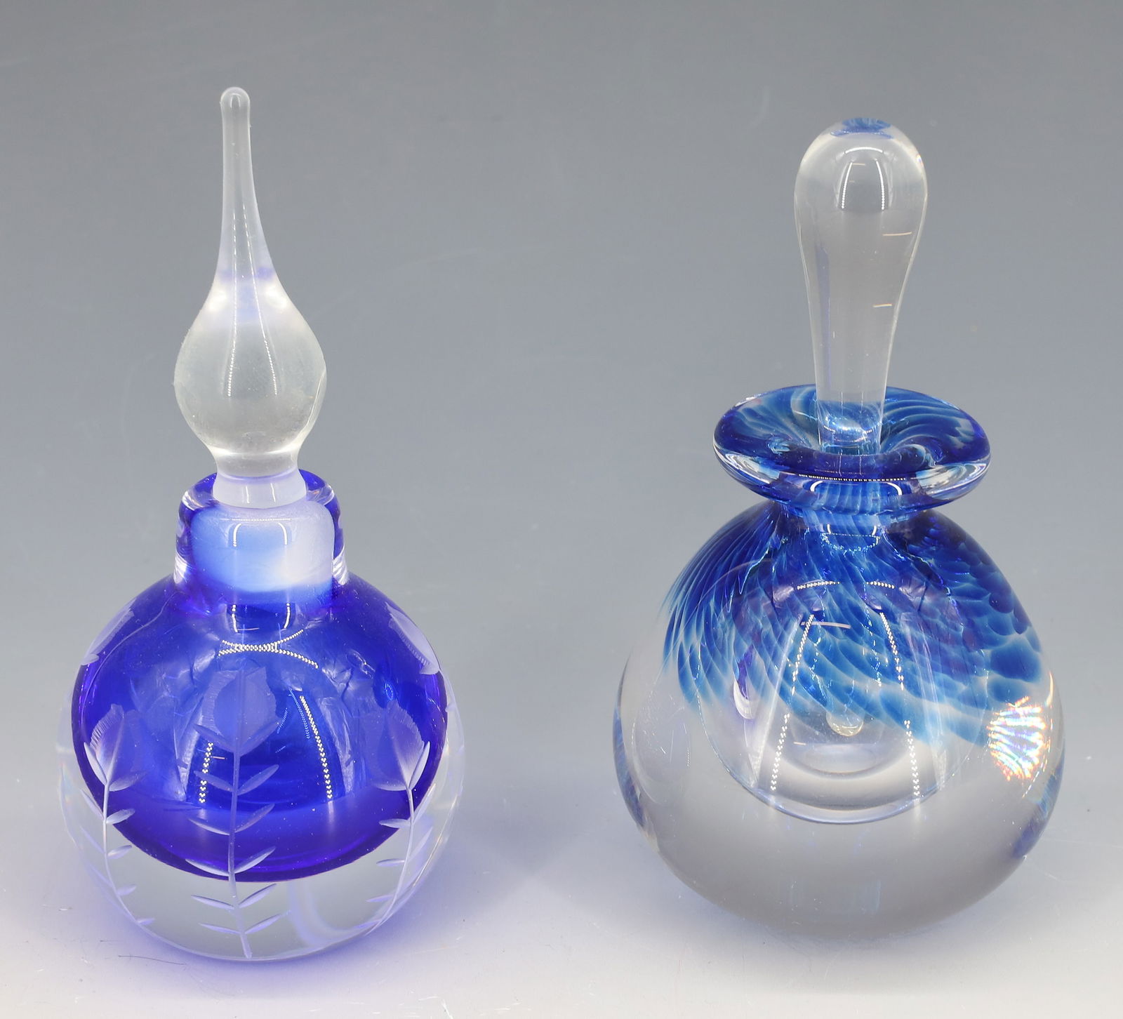 (2) SIGNED ART GLASS PERFUME BOTTLES: ONE VANDERMARK COBALT BLUE INTERIOR WITH ENGRAVED FLOWERS STEEPLE STOPPER AND ROBERT D. MATTHEWS BLUE SPATTER 5 1/2"H,5 3/4"H PLEASE READ CAREFULLY - Terms for Purchasing and Shipping of Auction Items