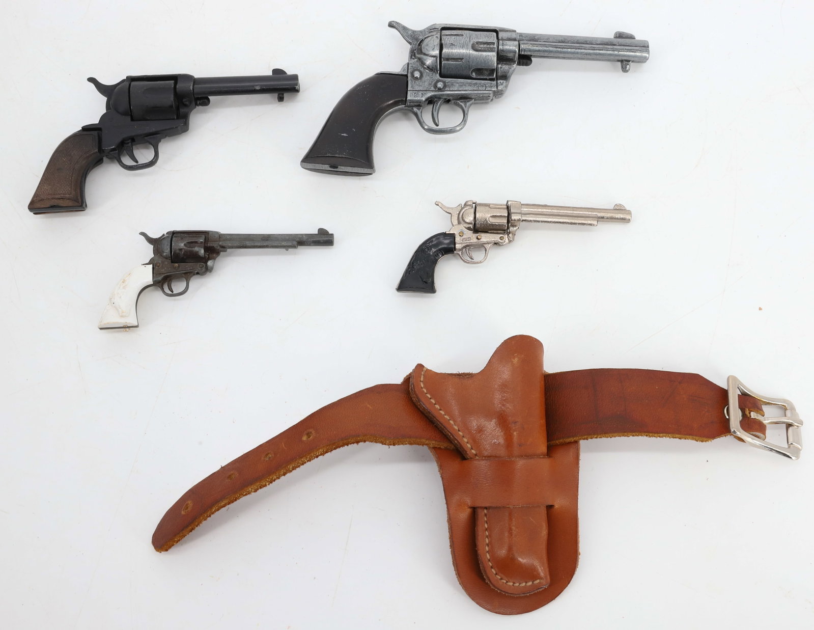 LOT OF MINIATURE REPLICA PISTOLS: INCLUDING: ONE MRKD. UNIWERK, ITALY TOTAL SIZE 3 3/4" L. WITH LEATHER HOLSTER. LARGEST IS 5" TOTAL LENGTH. SMALLEST BLACK HANDLE MRKD. JAPAN. PLEASE READ CAREFULLY BEFORE BIDDING. ALL PAYMENTS MUST BE