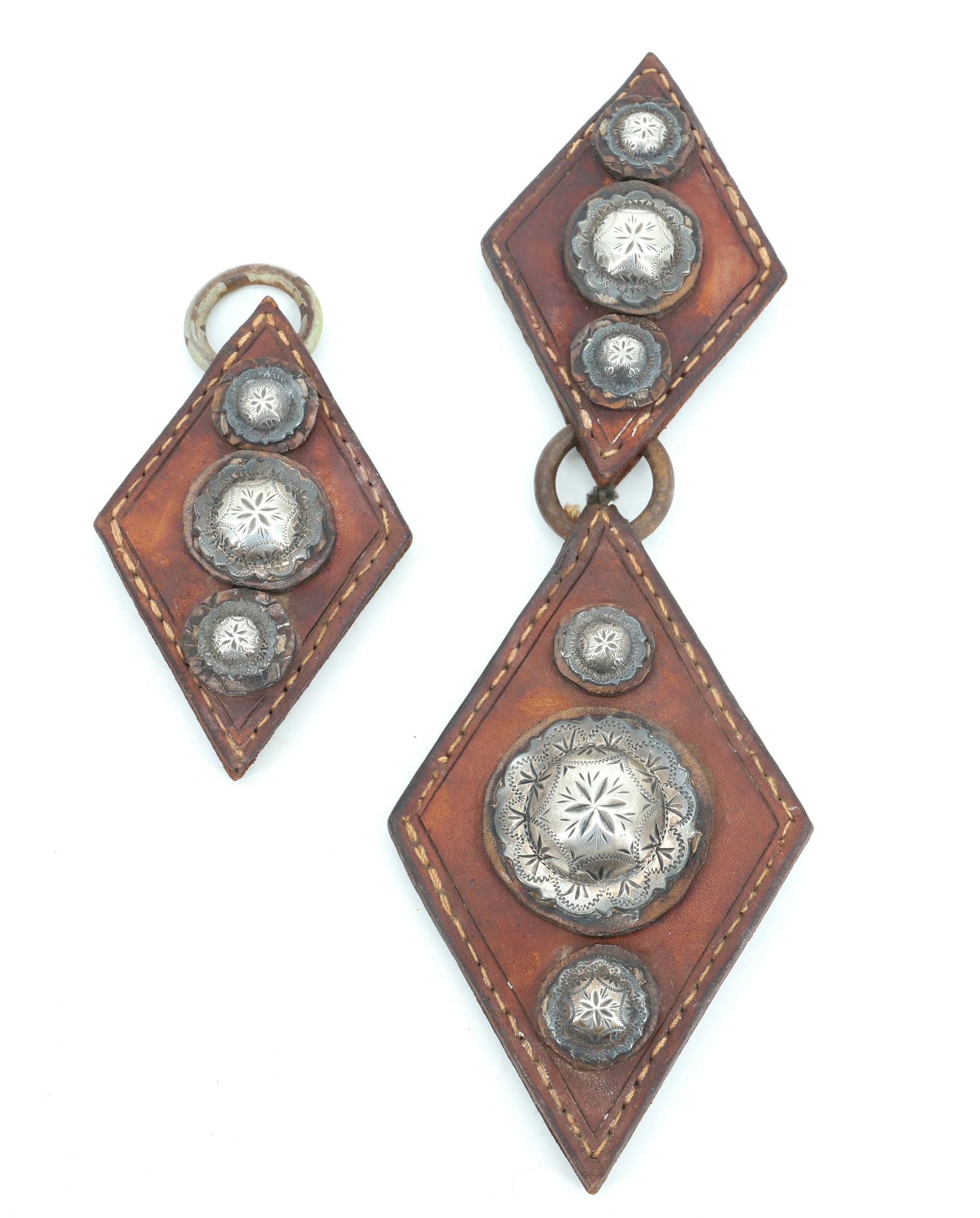 SILVER CONCHO / LEATHER ORNAMENTS: DECORATED SILVER CONCHOS MOUNTED ON DIAMOND SHAPED LEATHER. LARGEST CONCHO 1 1/2" D. PLEASE READ CAREFULLY - Terms for Purchasing and Shipping of Auction Items. Please read carefully before bidding. A