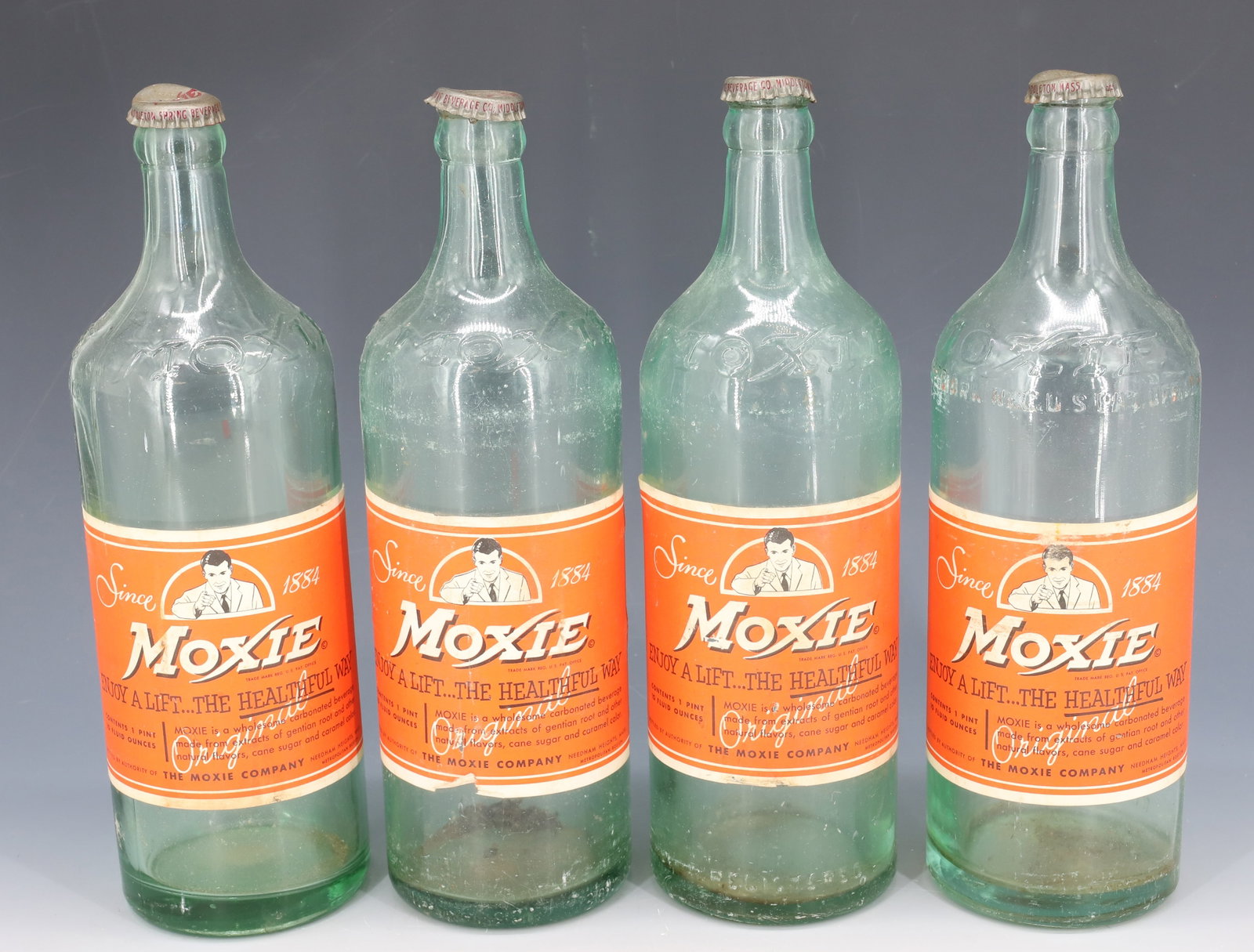(4) MOXIE SODA BOTTLES: ORIGINAL PAPER LABELS AND CAPS. 10 1/4" H. PLEASE READ CAREFULLY - Terms for Purchasing and Shipping of Auction Items. Please read carefully before bidding. All payments for purchases will be made thr