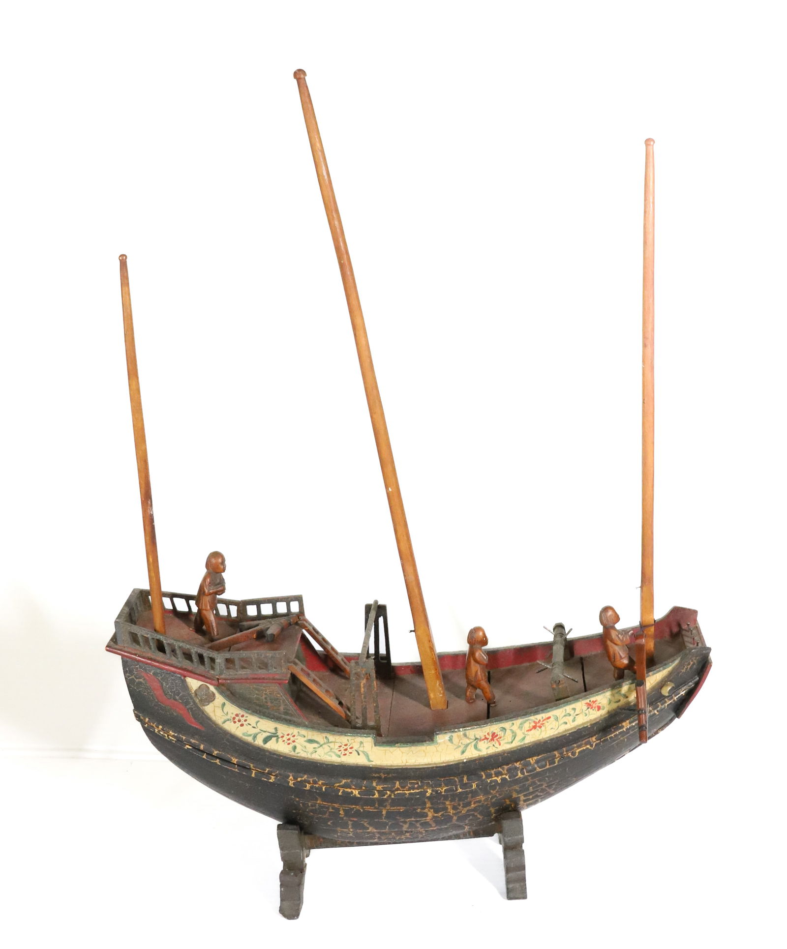 FOLK ART CARVED SHIP: CARVED AND PAINTED SHIP. THREE FIGURES ON DECK. 14 1/4" L. RESTS ON CARVED STAND. PLEASE READ CAREFULLY â€“ THIS IS AN IN-PERSON & ON-LINE AUCTION. SALE IS LOCATED IN HARMONY TOWNSHIP
