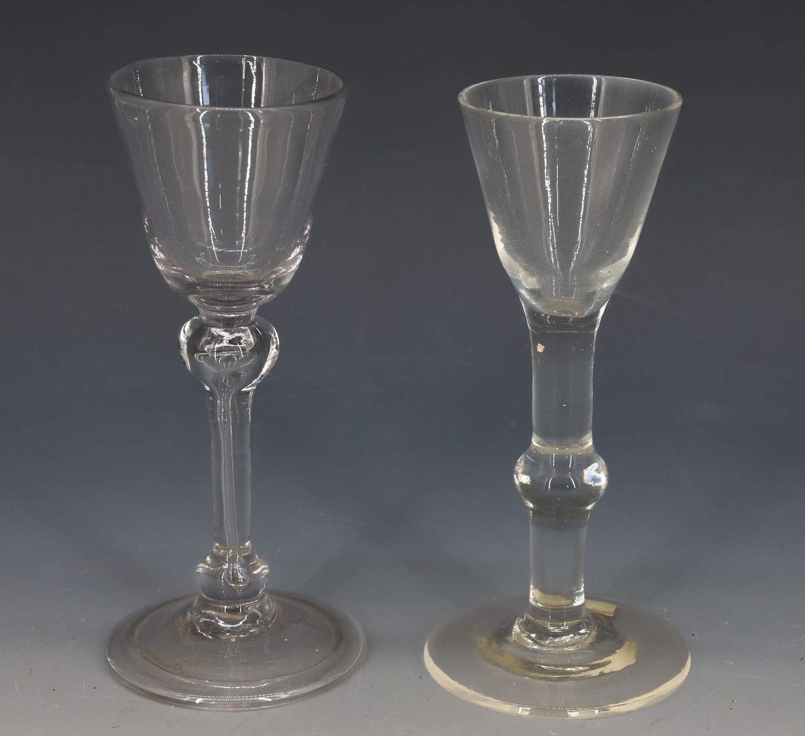 (2) EARLY BLOWN GLASS WINE GLASSES: (2) WINE GLASSES. ONE WITH FOLDED BASE RIM. 5 7/8" AND 6" HEIGHTS. PLEASE READ CAREFULLY â€“ THIS IS AN IN-PERSON & ON-LINE AUCTION. SALE IS LOCATED IN HARMONY TOWNSHIP, PHILLIPSBURG,