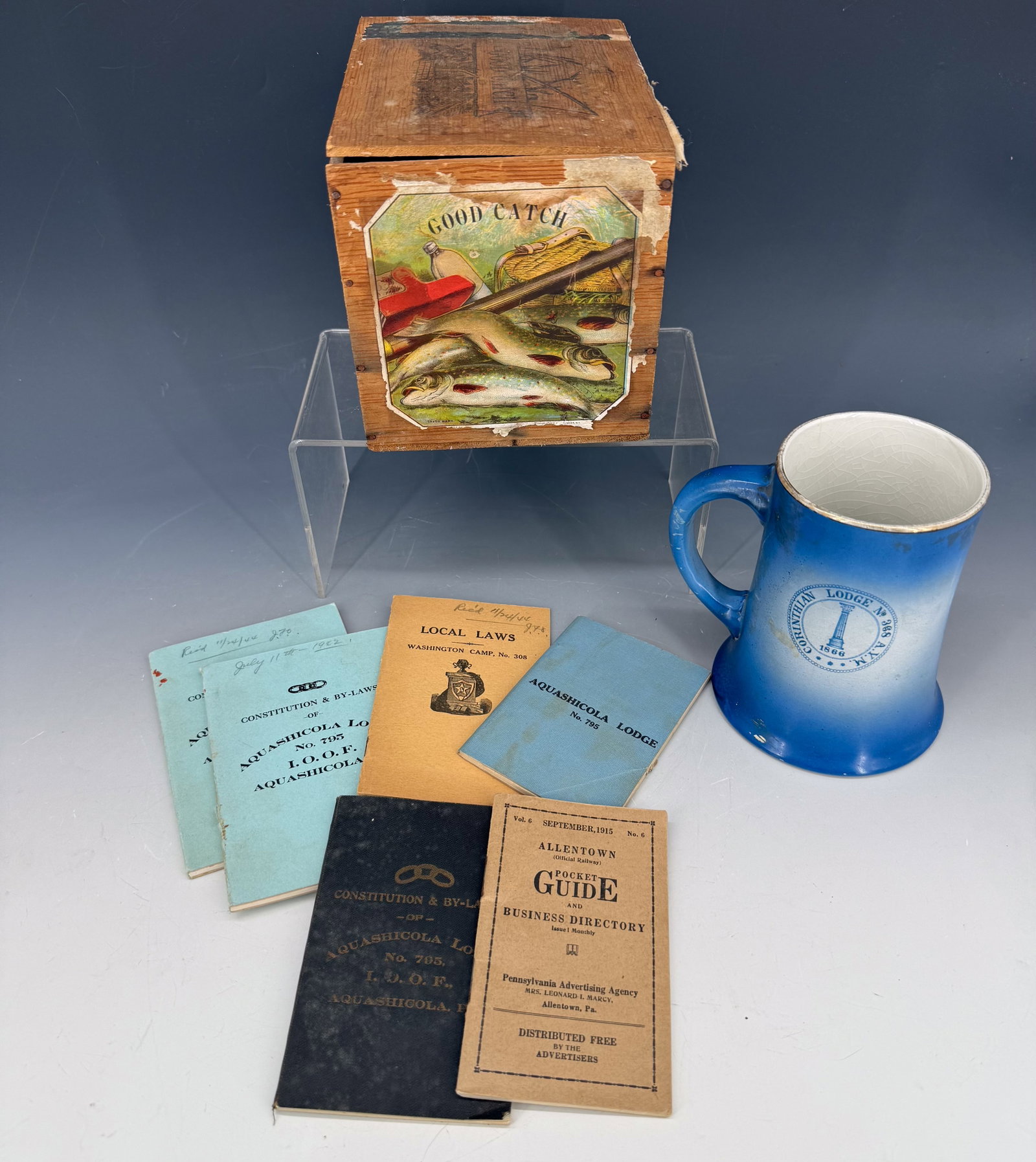 LOT OF LODGE PAMPHLETS, MUG AND CIGAR BOX: PA LODGE PAMPHLETS 1930S ERA. 1866-1904 CORINTHIAN LODGE MUG 5" H. WITH "GOOD CATCH" PAPER LITHO ON WOODEN CIGAR BOX 7 1/2" L. PLEASE READ CAREFULLY - Terms for Purchasing and Shipping of Auction Item