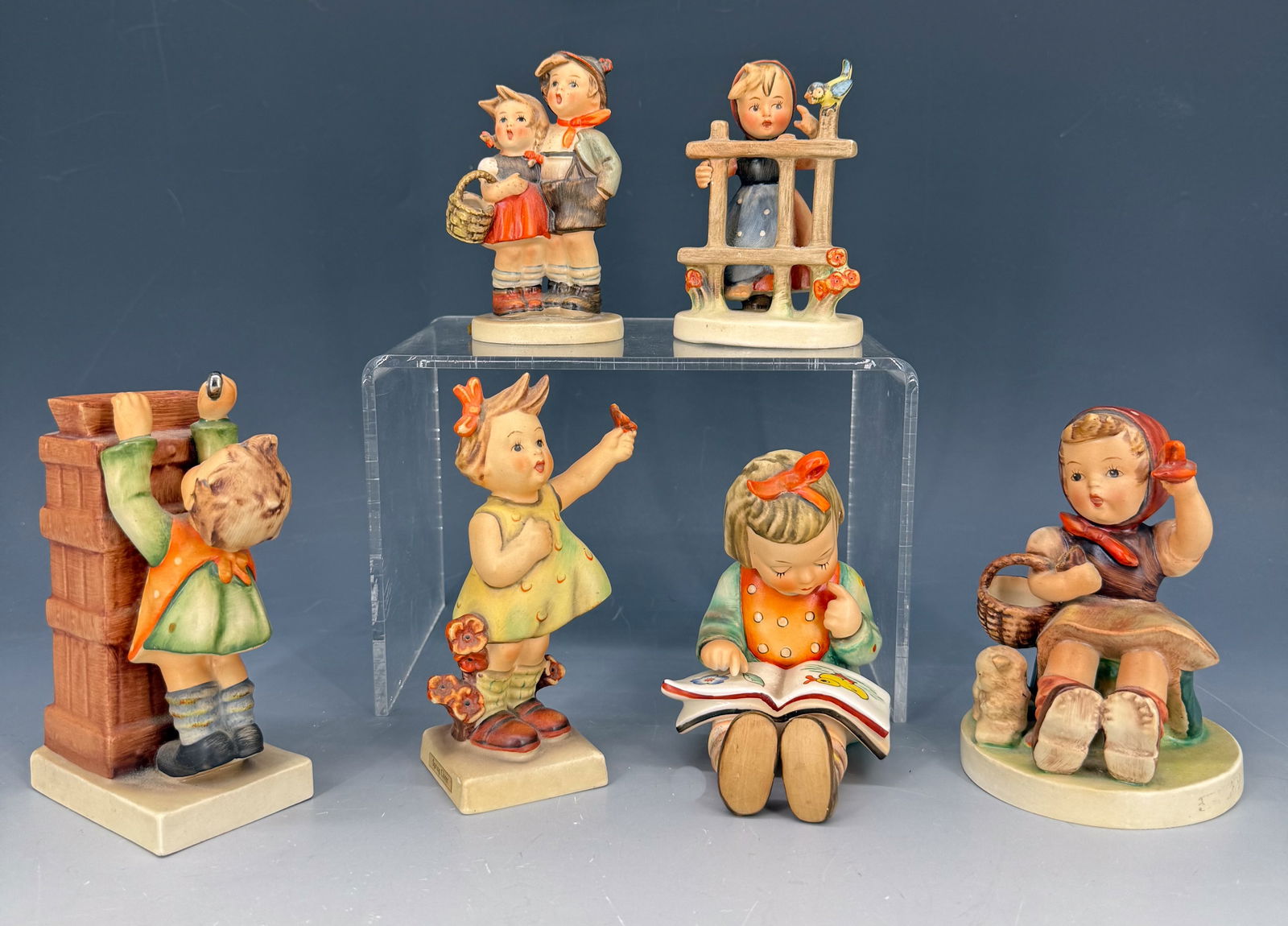 LOT OF (6) HUMMEL FIGURINES: MRKD. ON BOTTOM "W. GERMANY". TALLEST IS 5" H. MRKD. "THE MAIL IS HERE" BANK. BOY AND GIRL MRKD. "SURPRISE". GIRL WITH FLOWER IN AIR "SPRING CHEER". PLEASE READ CAREFULLY - Terms for Purchasing and Sh