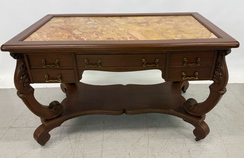 MARBLE TOP WRITING TABLE / DESK: FRAMED MARBLE TOP ABOVE FIVE DRAWERS WITH BRASS HARDWARE. SHELF BELOW. CURVED LEGS RESTING ON CASTERS. 30" X 48" X 28". PLEASE READ CAREFULLY - Terms for Purchasing and Shipping of Auction Items. Plea